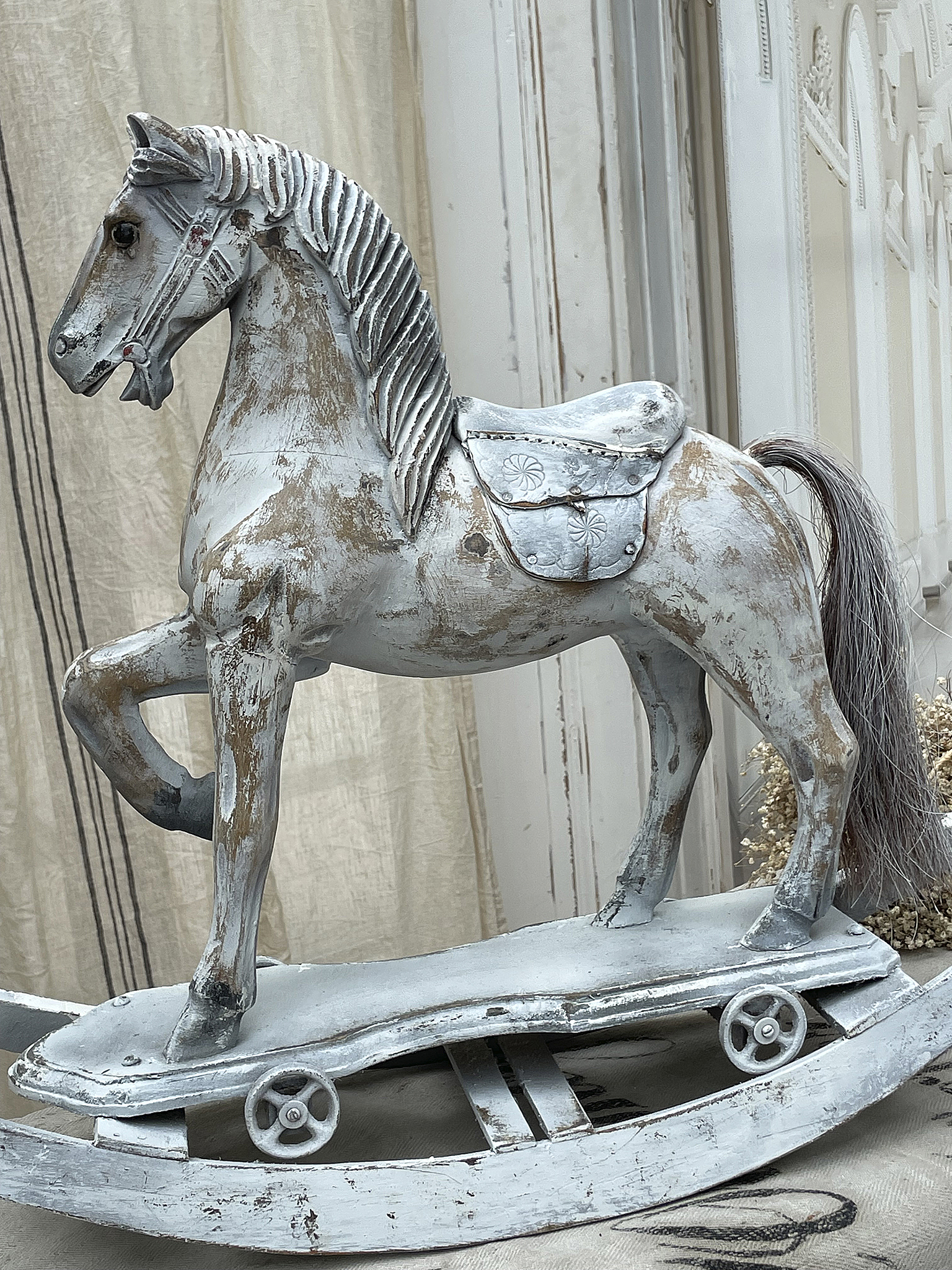 Schaukelpferd aus Holz in shabby-chic Stil, dekorativ und kinderfreundlich.