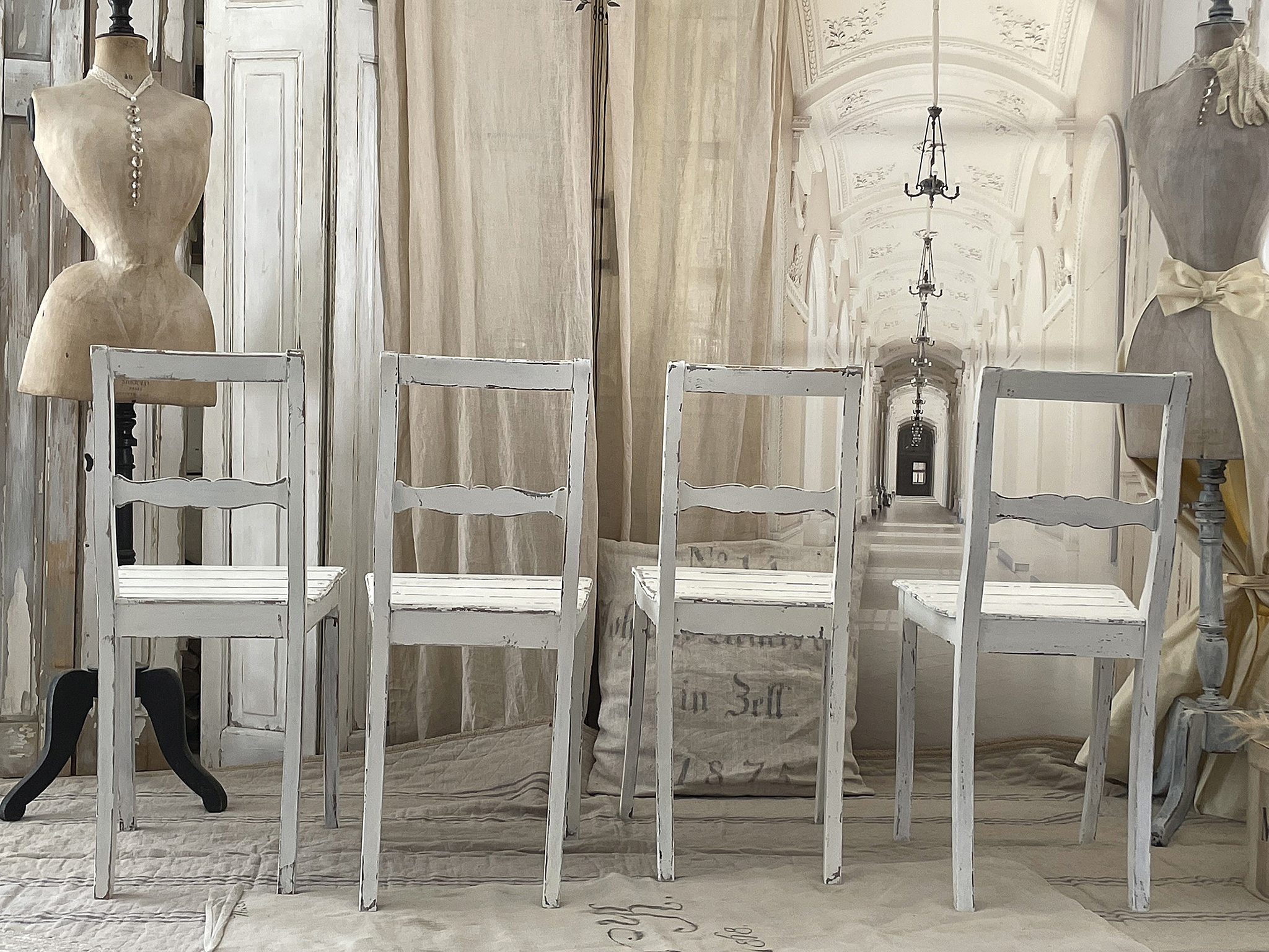 Elegante, vintage Stühle in einem stilvollen Innenraum Vier graue Vintage-Stühle stehen in einem ästhetischen Raum mit einer Schneiderpuppe und einem hellen Hintergrund.