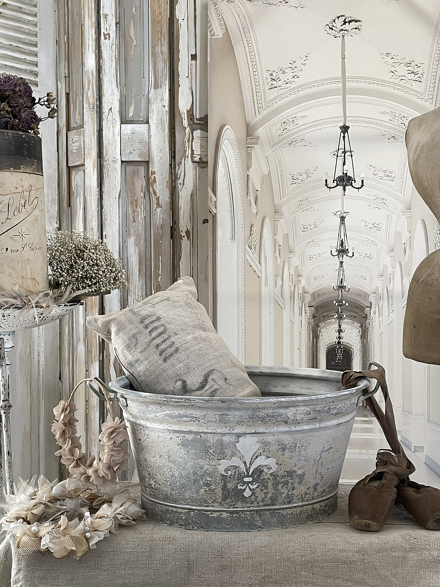 Dekorative Etagere mit Vintage-Gegenständen in einem eleganten Raum Dekoration mit einem antiken Eimer, Kissen und Gestecken in einem stilvollen Innenraum