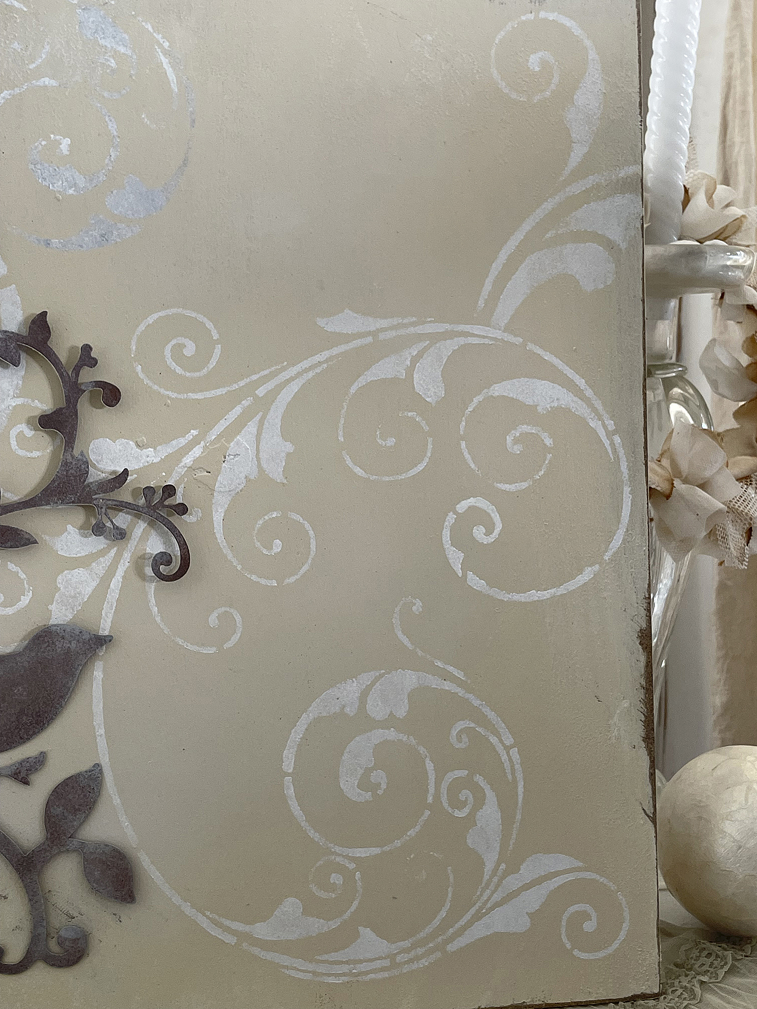 Dekorativer Wandbelag mit floralen Motiven Detailaufnahme eines Wandbelags mit eleganten, weißen floralen Verzierungen und einem metallischen Ornament