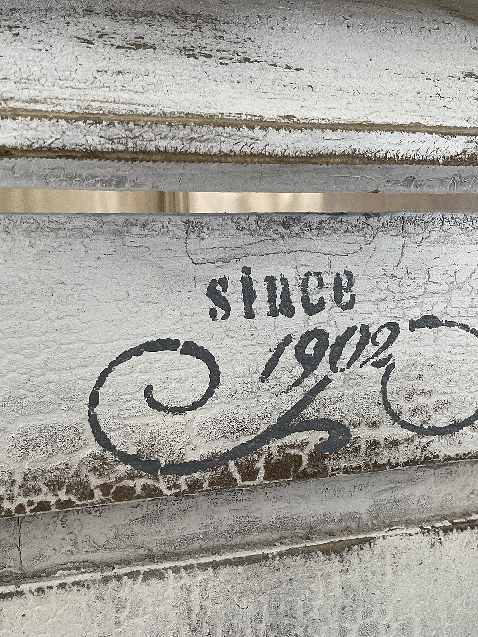 Deko-Element mit antikem Schriftzug seit 1902 Nahaufnahme eines Deko-Elements mit der Aufschrift 'since 1902' in stilvollem Design