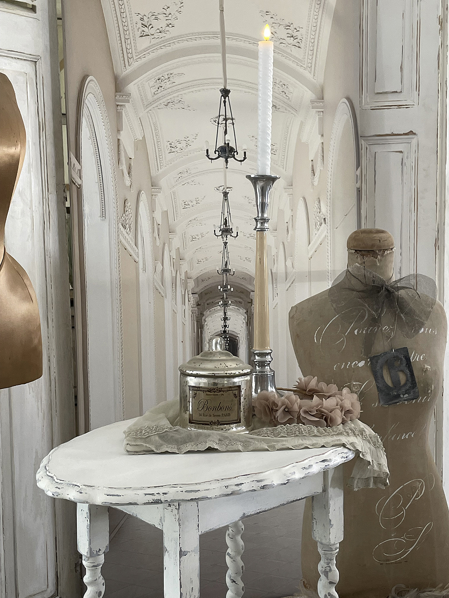 Eleganter Tisch mit Kerze und Dekoration in einem stilvollen Ambiente Stilvoll dekorierter Tisch mit Kerze, Glaskonserve und einer kreativen Mannequin-Hülle.