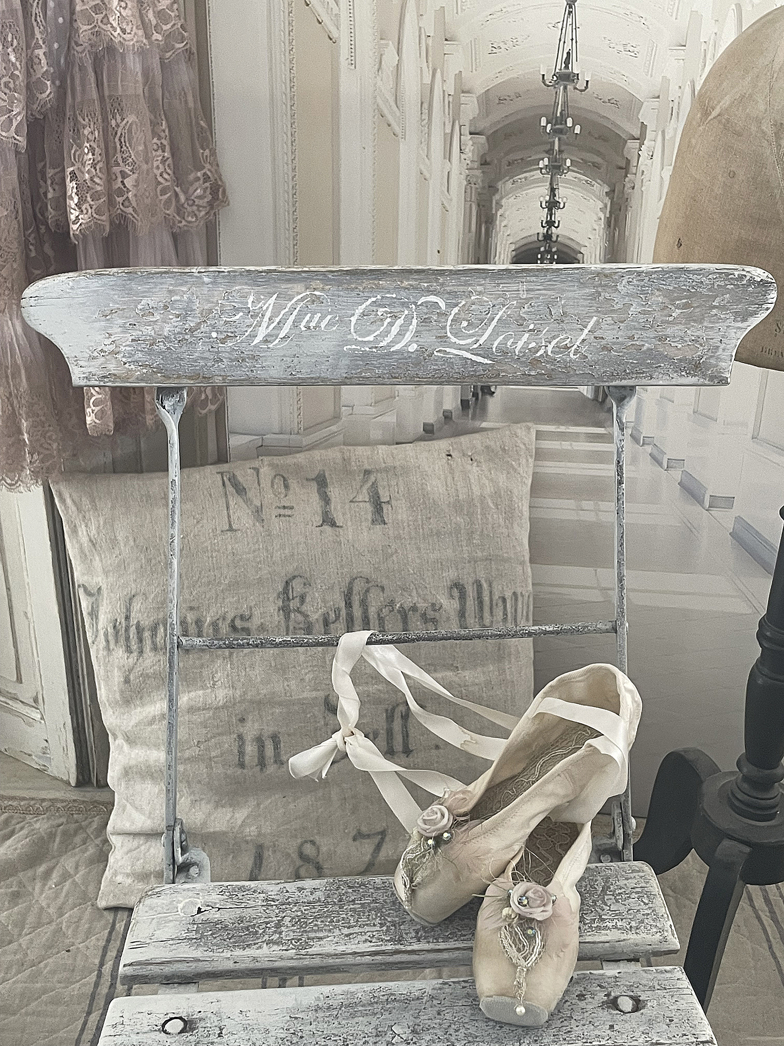 Vintage Ballettschuhe auf einem Windfangstuhl Deko mit Vintage-Ballettschuhen auf einem alten Stuhl, umgeben von eleganter Garderobe