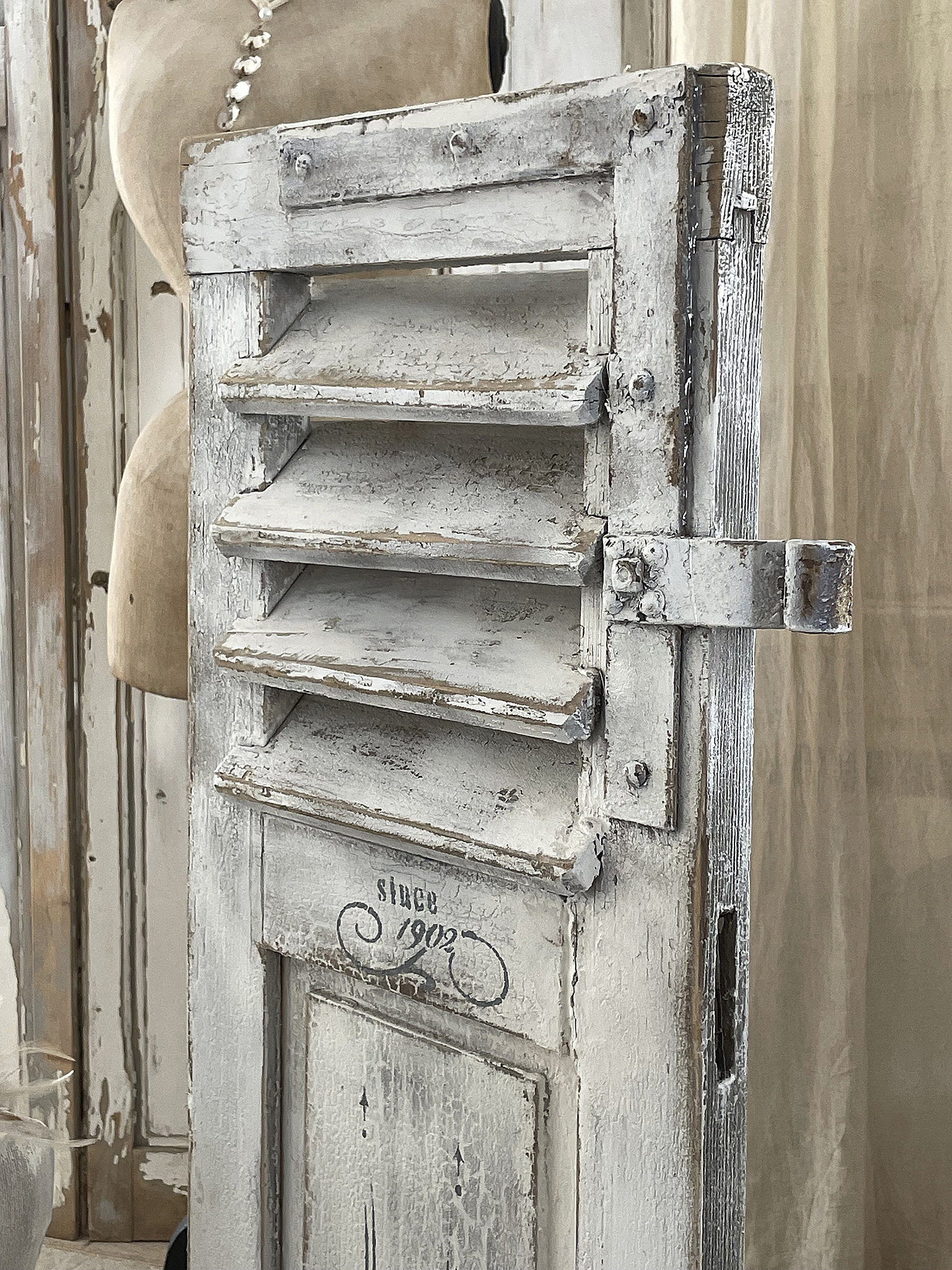 Vintage weiße Fensterläden aus Holz, seit 1902 Detailansicht eines alten weißen Fensterladens mit der Aufschrift seit 1902