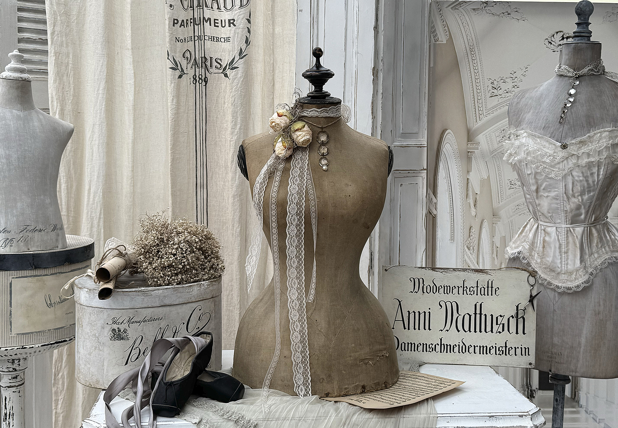 Elegante Schneiderpuppen mit vintage Accessoires und Dekoration Schneiderpuppen präsentiert mit schönen Bändern, Blumen und einem nostalgischen Hintergrund