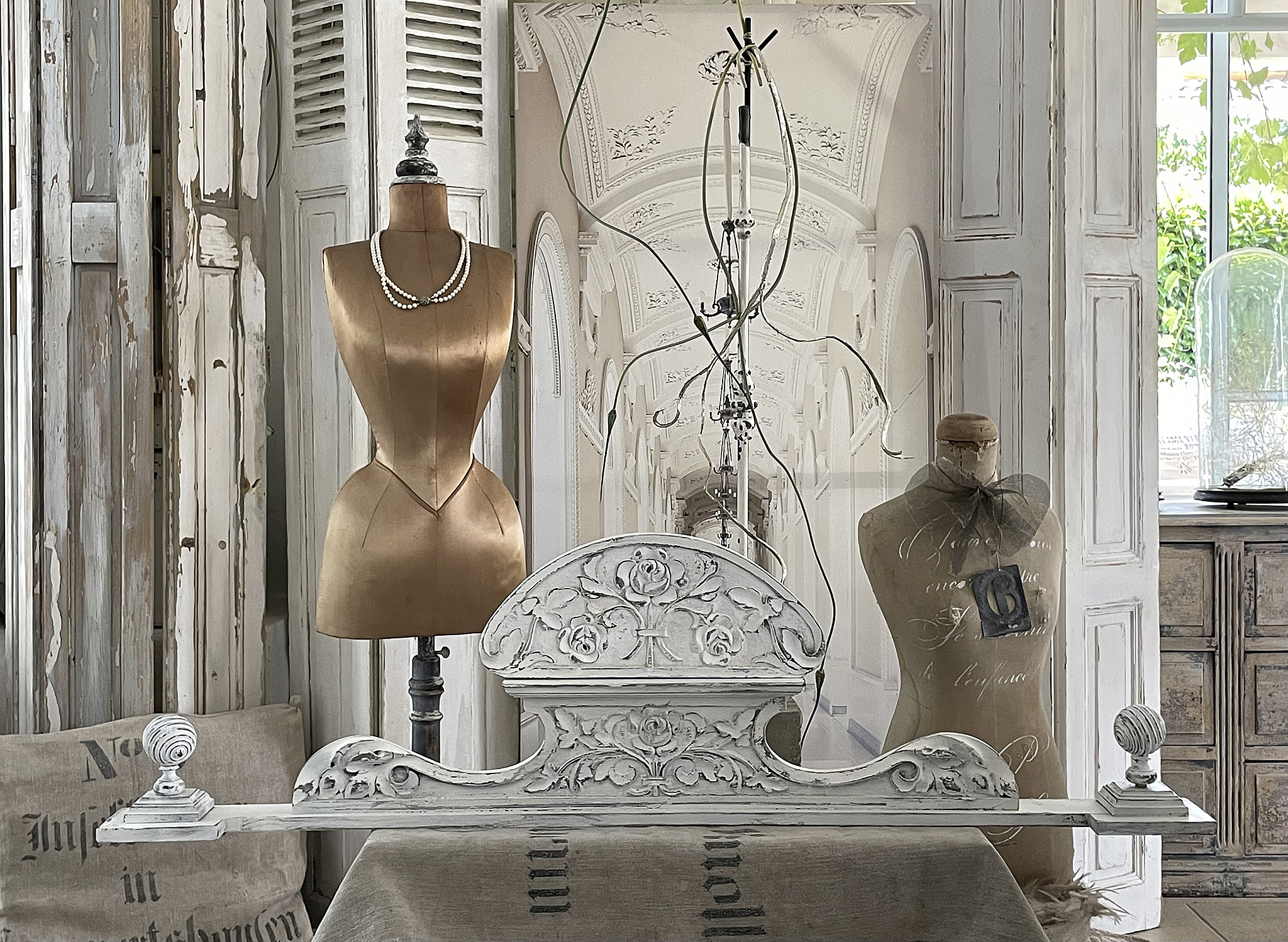Elegante Dekoration mit Schneiderpuppe und antikem Bettkopfteil Schneiderpuppe und antikes Bettkopfteil in stilvollem Interieur