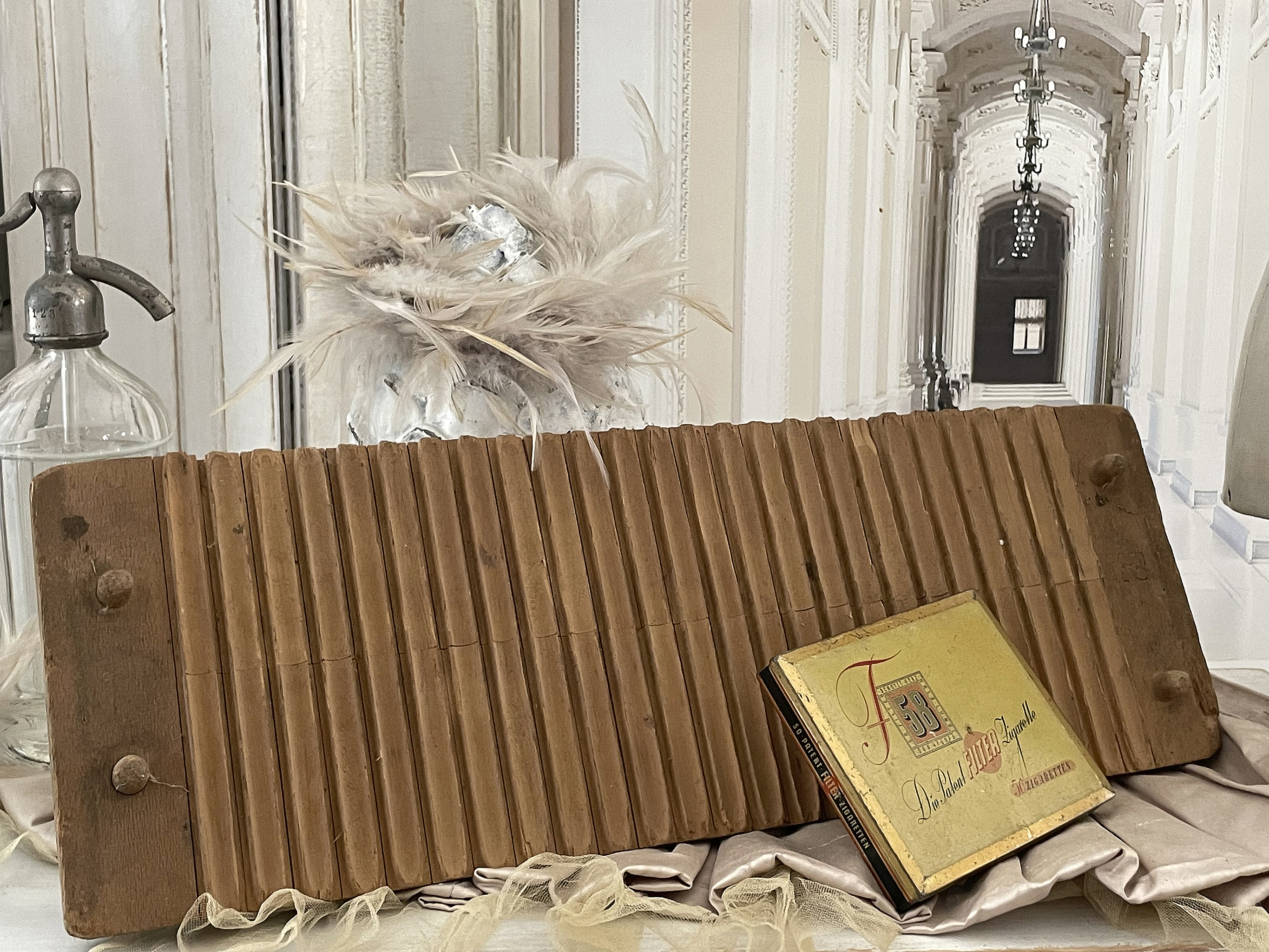 Antike Holzform für Backwaren und nostalgisches Rezeptbuch auf einem eleganten Tisch