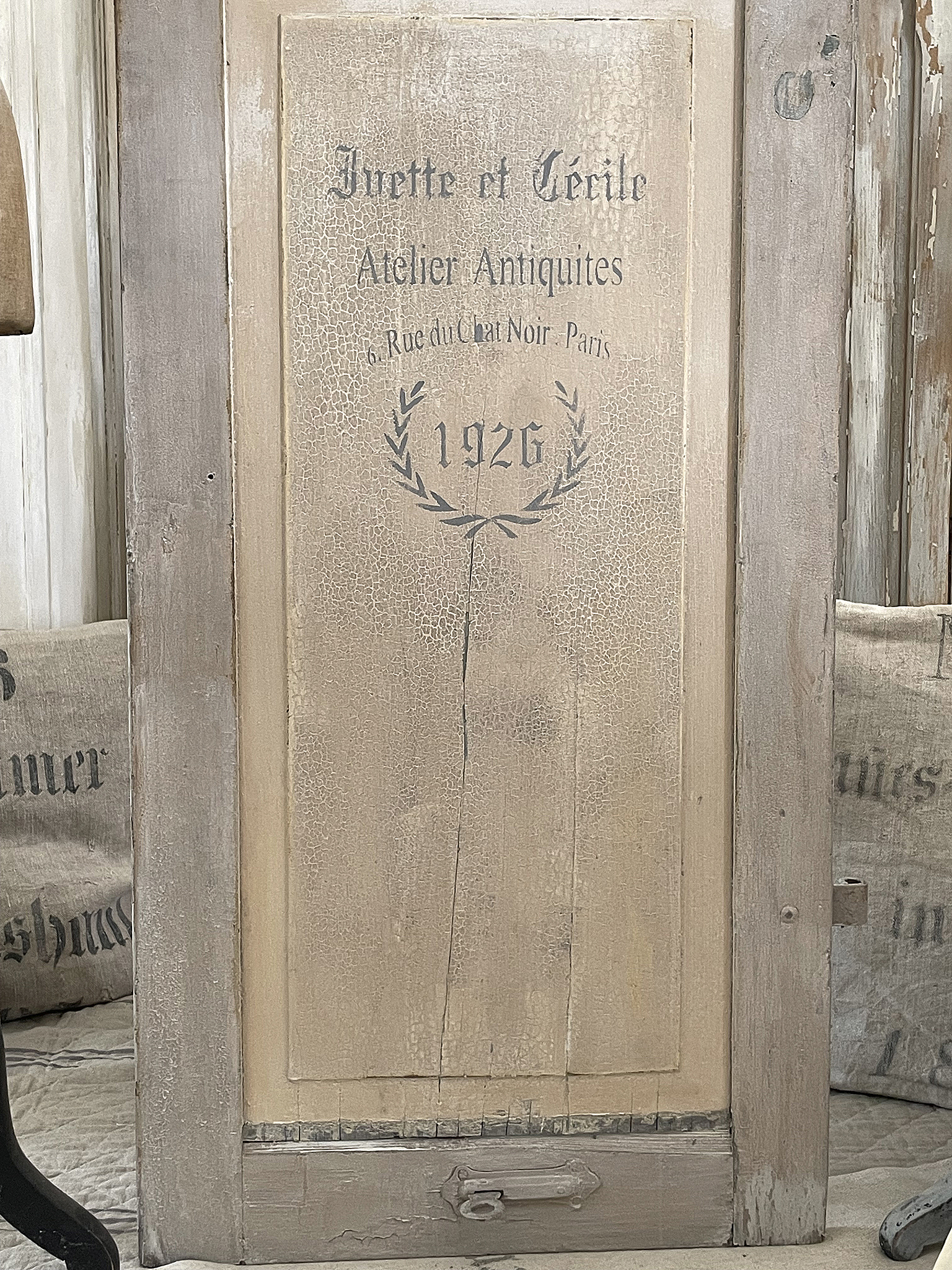 Antike Holztafel von 1926 mit der Aufschrift "Atelier Antiquités" Detailansicht einer antiken Holztafel mit dem Schriftzug "Invette et Cécile, Atelier Antiquités, 6. Rue du Chat Noir, Paris, 1926"