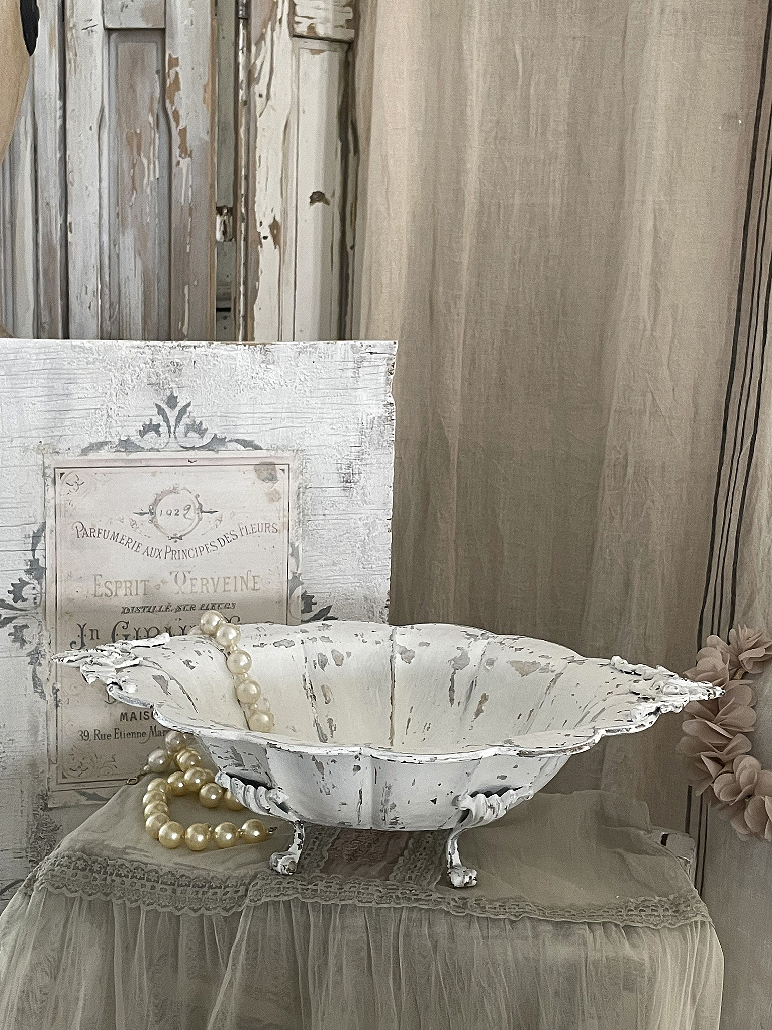 Dekorative Schale im Vintage-Stil mit Perlenkette Vintage-Schale aus weißem Holz mit Perlenkette auf einem Tisch