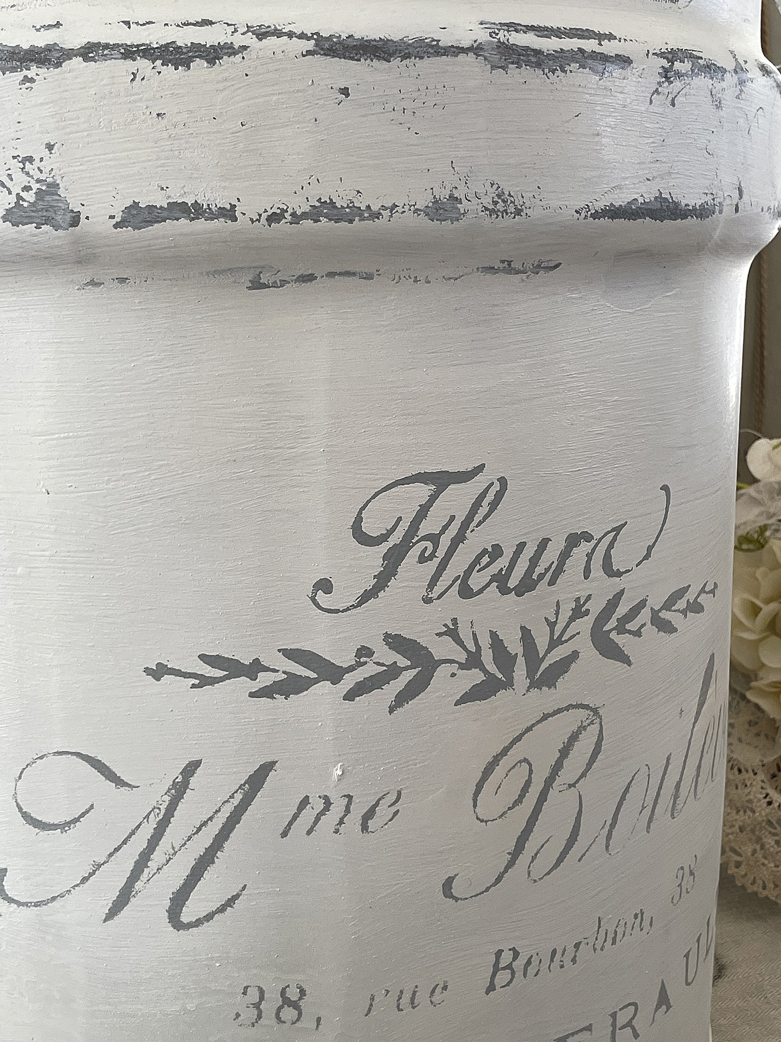 Dekorative Vintage-Blume mit beschriftetem Topf Nahaufnahme eines vintage-inspirierten Blumentopfes mit eleganter Schrift und dekorativen Elementen.