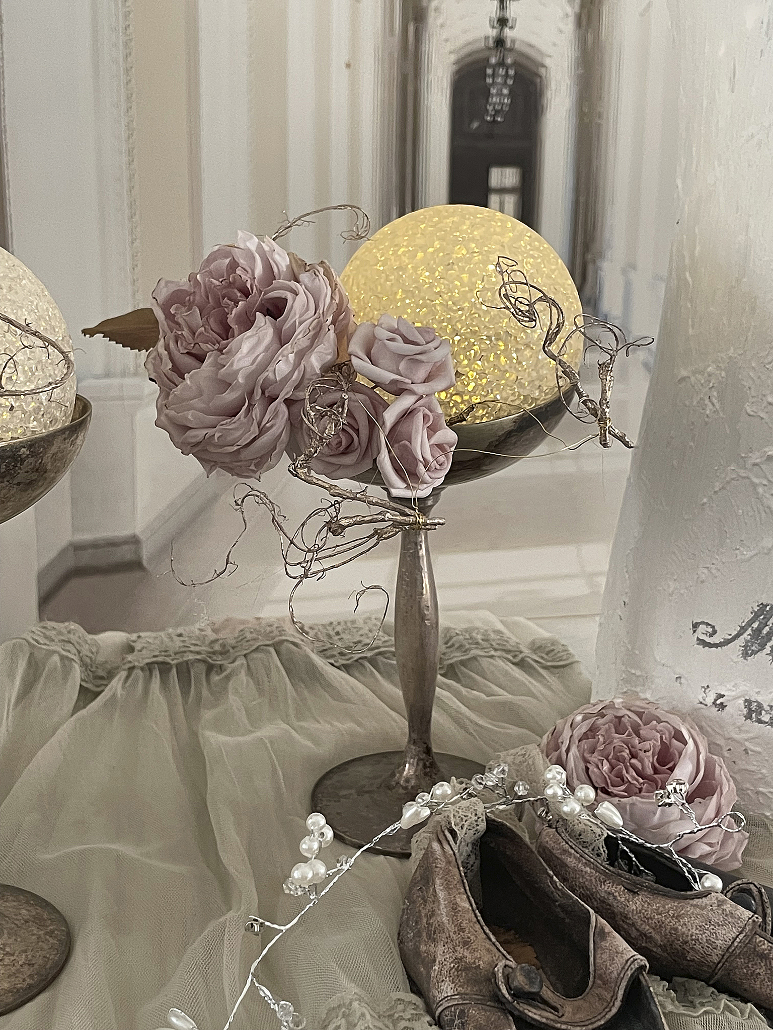 Dekorative Tischarrangements mit Rosen und leuchtenden Kugeln Schöne Tischdekoration mit künstlichen Rosen und glühenden Glaskugeln auf einem eleganten Tisch