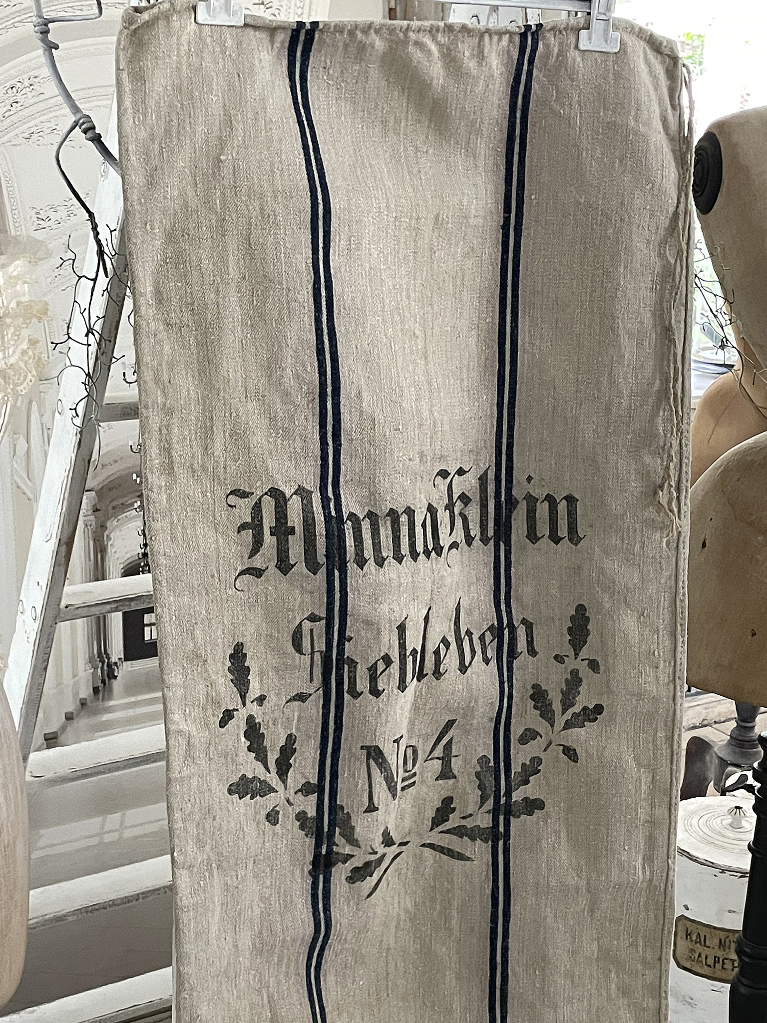 Leinenstoff mit dem Schriftzug 'Mannaklin' und dekorativen Elementen, Nummer 4