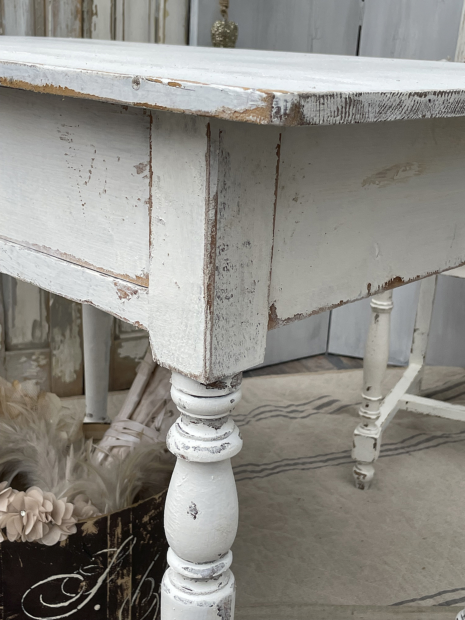 Dekorativer, vintage Tisch in Weiß mit abgenutztem Look Detailansicht eines weißen Tisches mit rustikalem Charme und shabby chic Akzenten