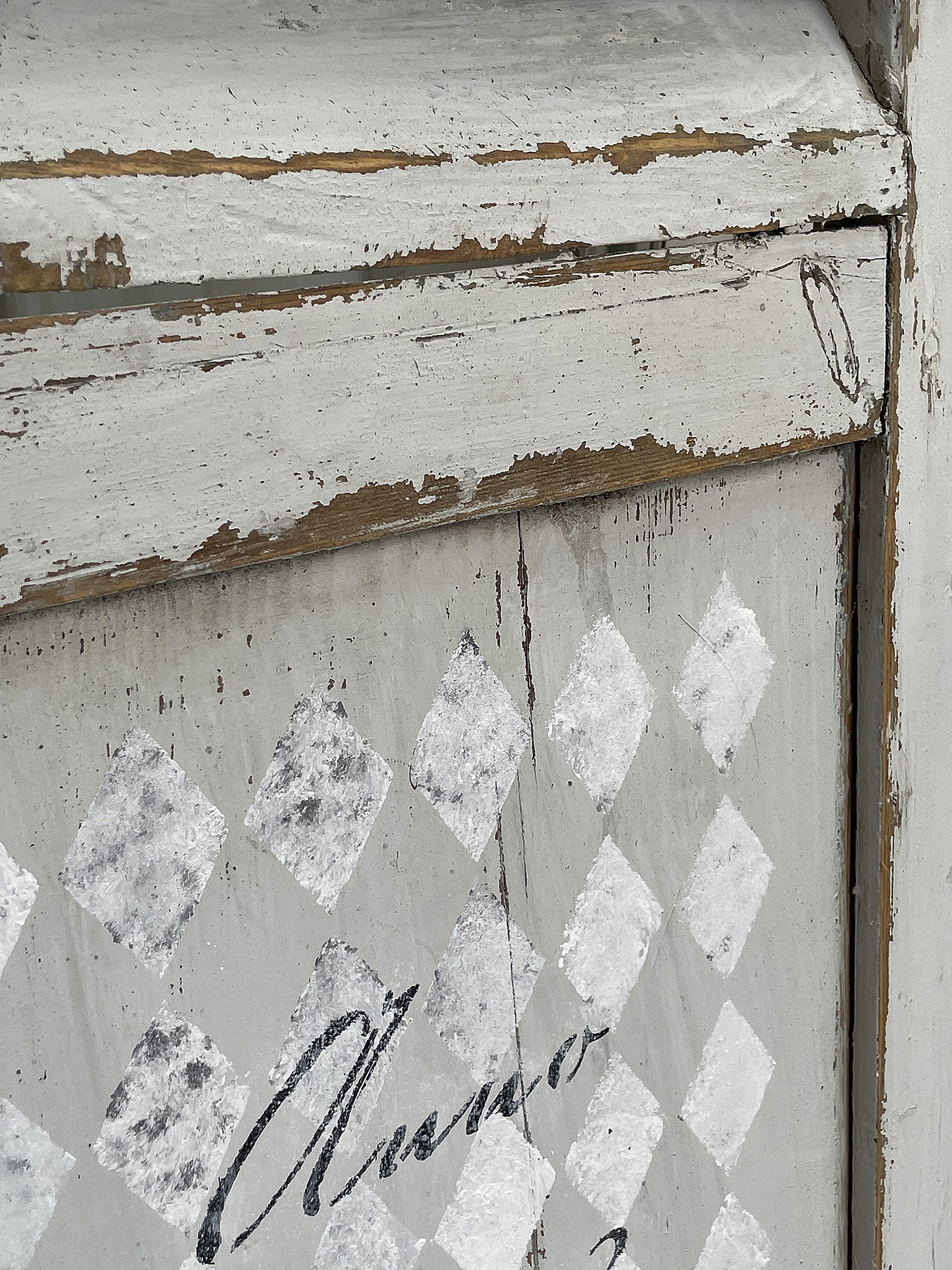 Antike Holzschrankdetails mit kunstvollem, abgenutztem Finish Nahaufnahme eines alten Holzschrankes mit dekorativen rautenförmigen Mustern in Grau und Weiß