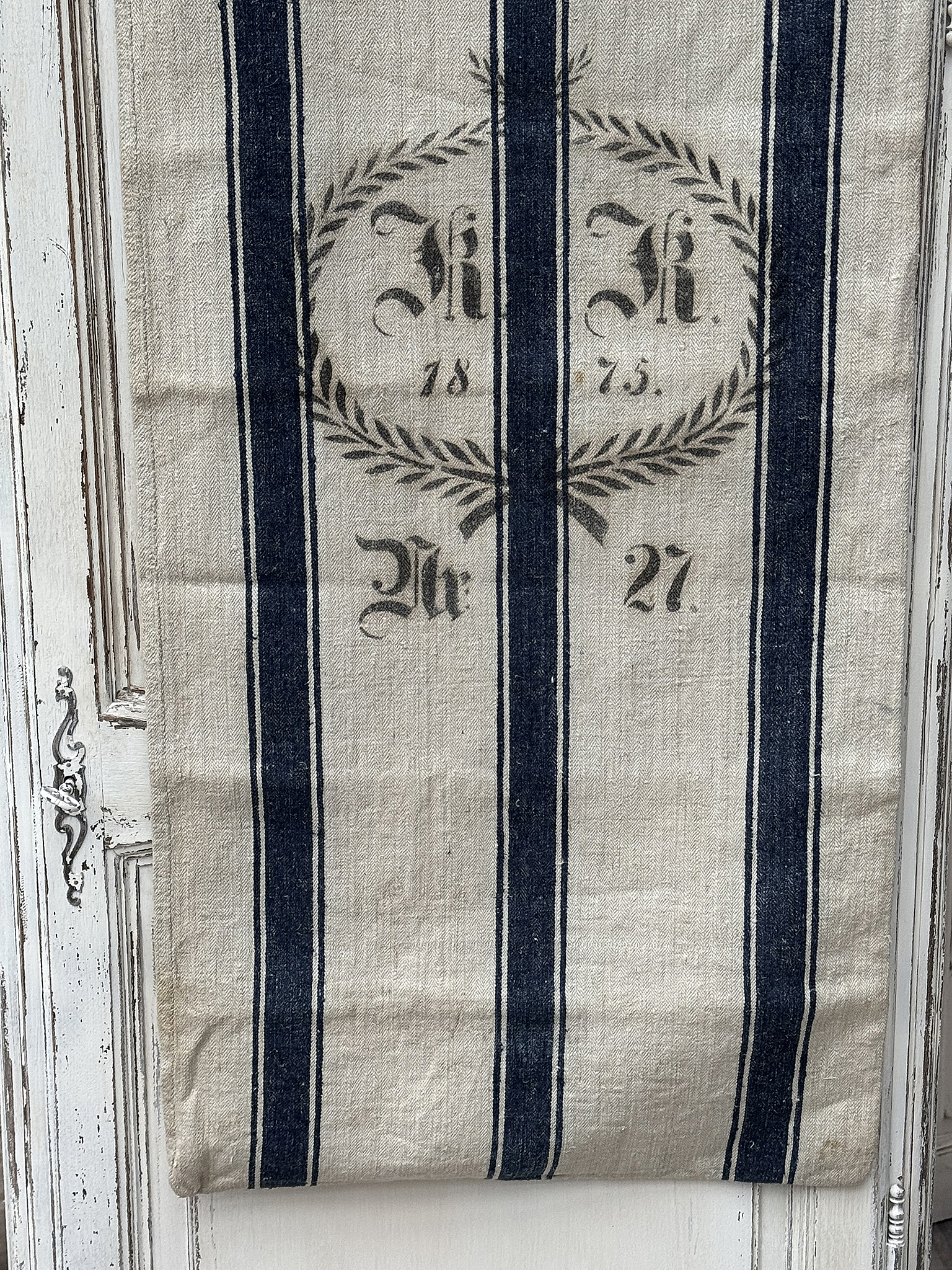 Detailaufnahme eines rustikalen Tuchs mit Streifenmuster und historischen Daten