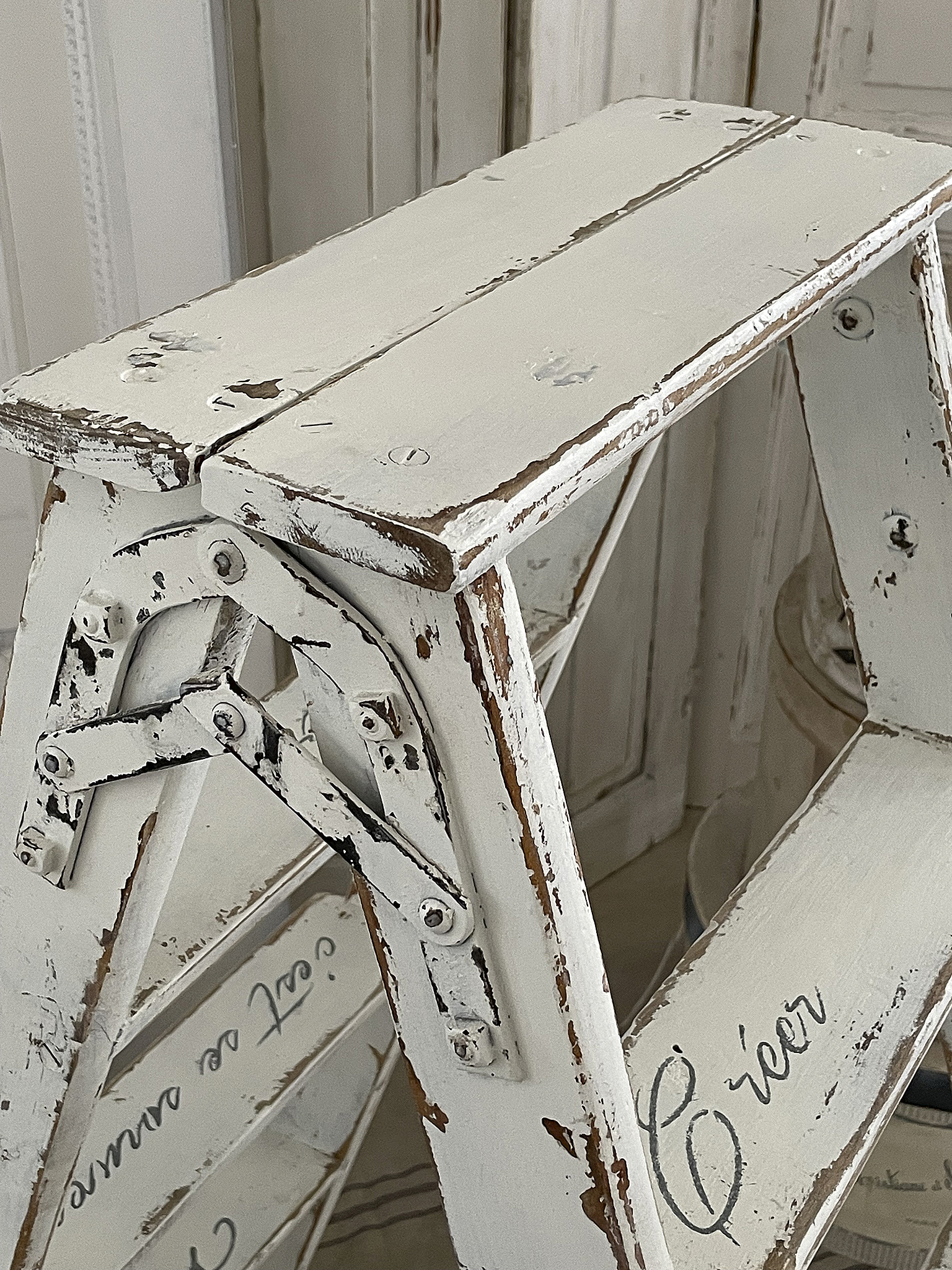 Vintage Holzleiter in Weiß mit Gebrauchsspuren Detailansicht einer weißen Holzleiter mit Shabby-Chic-Optik