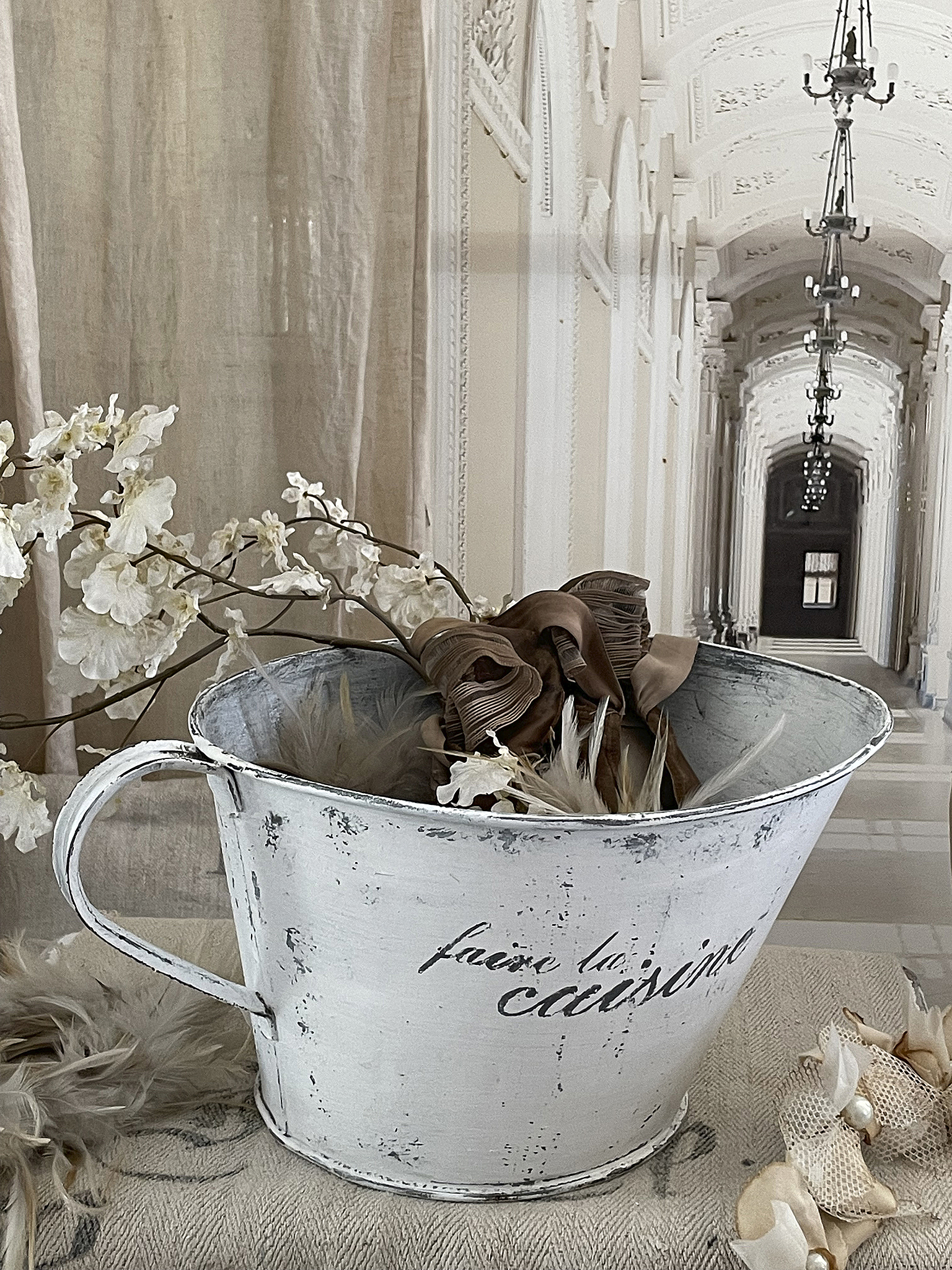 Dekorativer Eimer mit Blumenarrangement für die Wohnung Weißer Rustikal-Eimer mit floralem Arrangement und goldenen Details