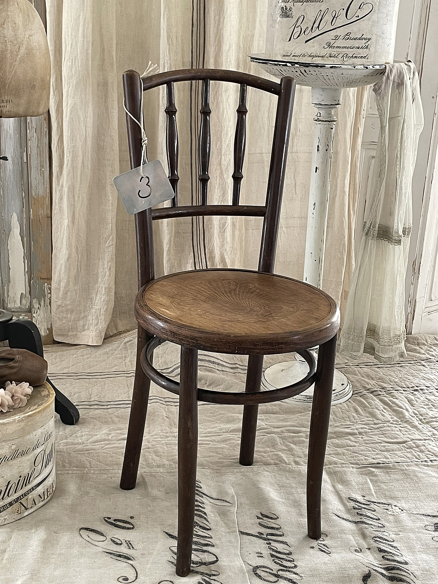 Vintage Holzstuhl mit einem rustikalen Design und einer runden Sitzfläche Brauner Holzstuhl mit runder Sitzfläche und fünf senkrechten Stäben in der Rückenlehne