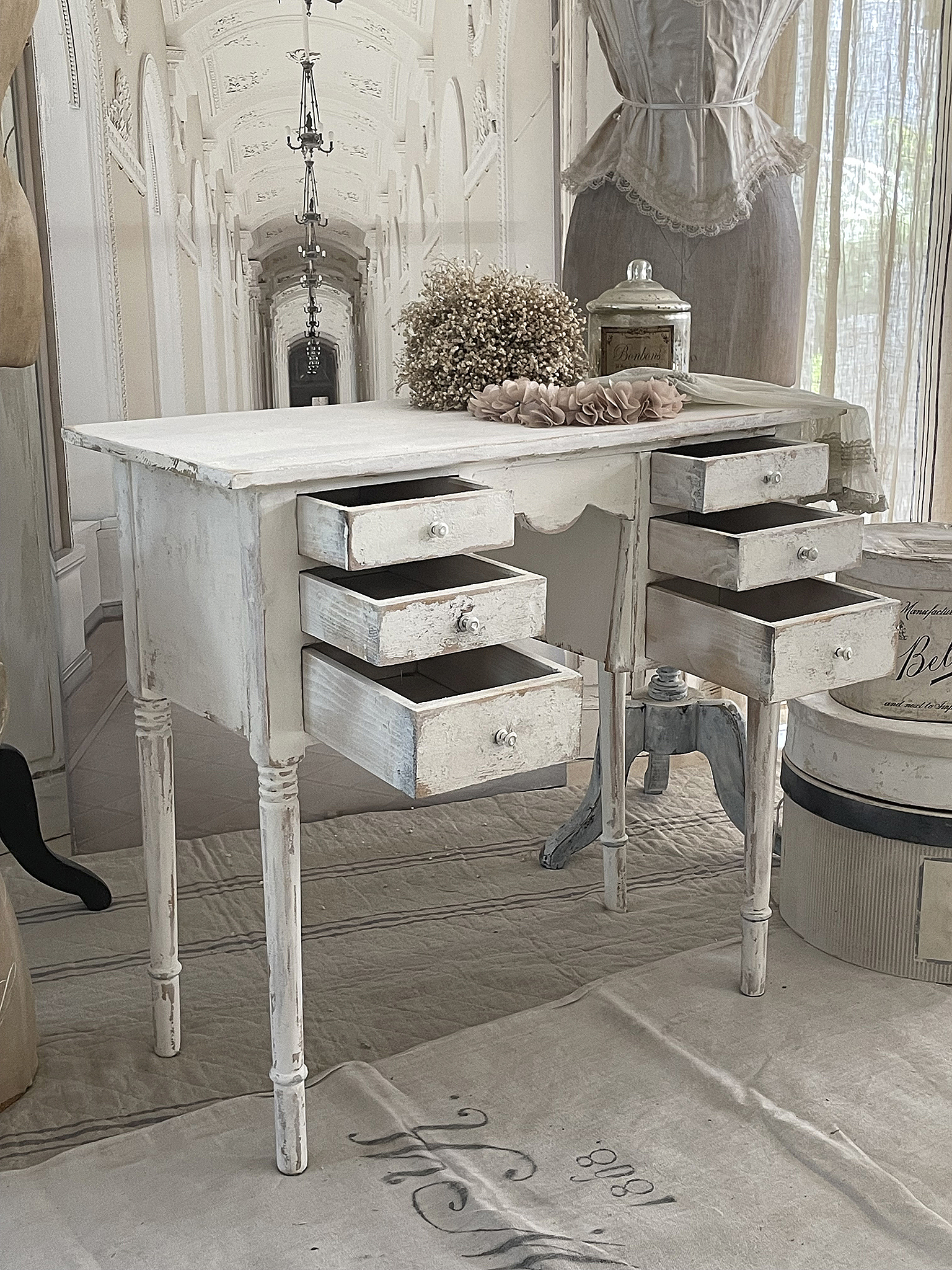 Vintage Schreibtisch mit Schubladen im Landhausstil Weißer Vintage Schreibtisch mit mehreren Schubladen in einem eleganten Raum