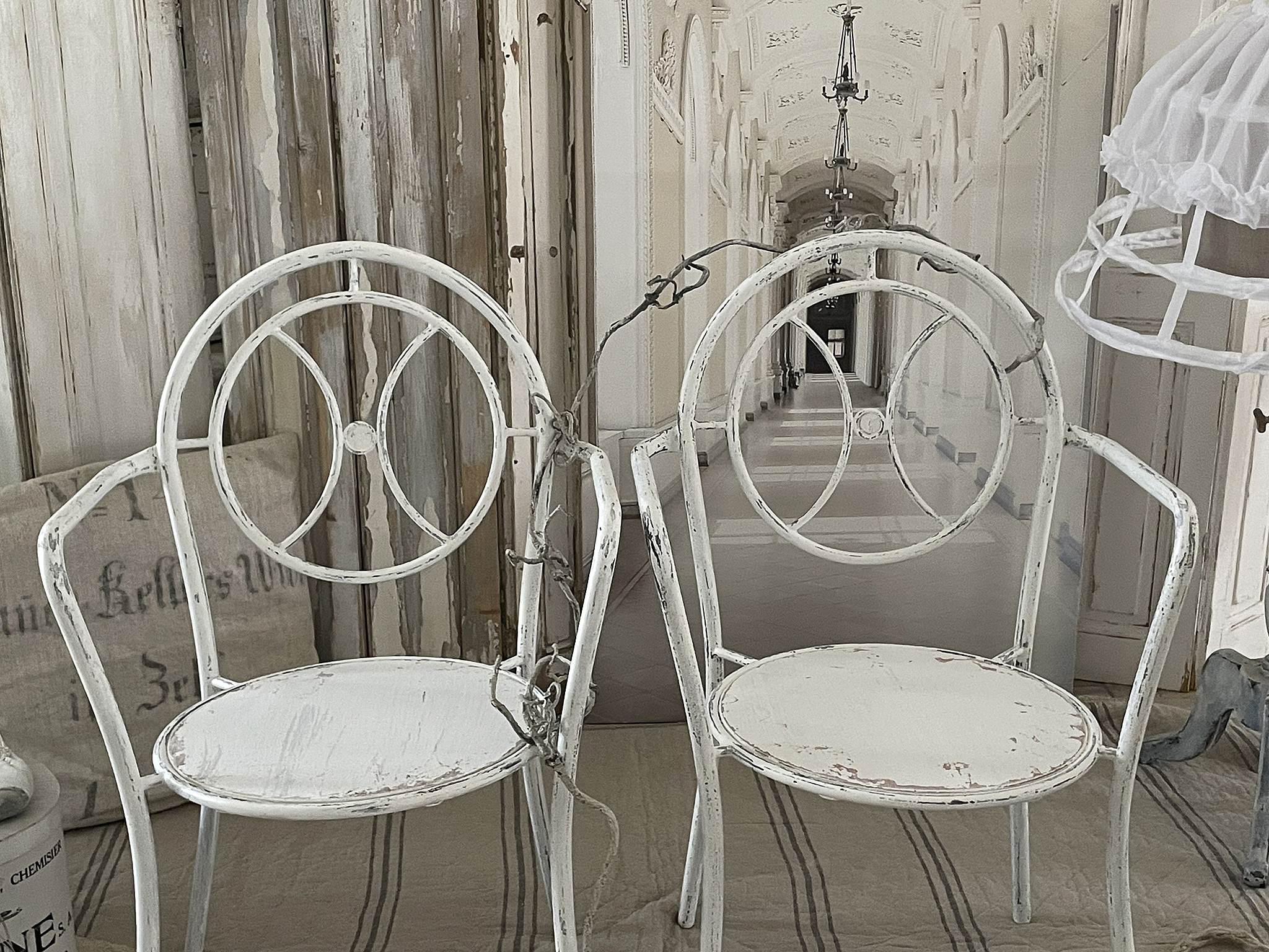 Zwei Vintage-Stühle im Shabby-Chic-Stil Moderne weiße Stühle mit abgenutztem Finish in einem eleganten Raum