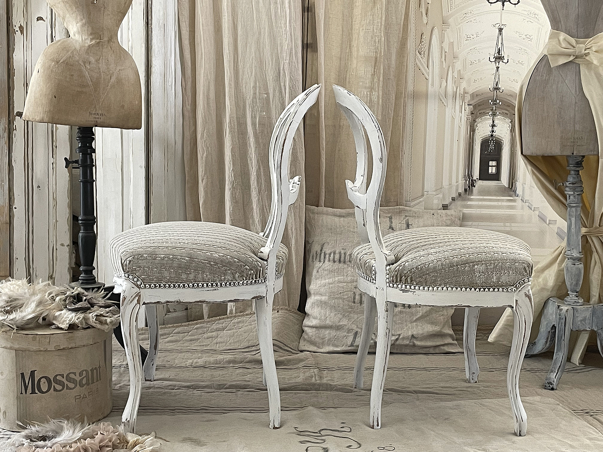 Elegante weiße Stühle im Vintage-Stil Zwei elegante weiße Vintage-Stühle mit gestepptem Polster in einem stilvollen Raum