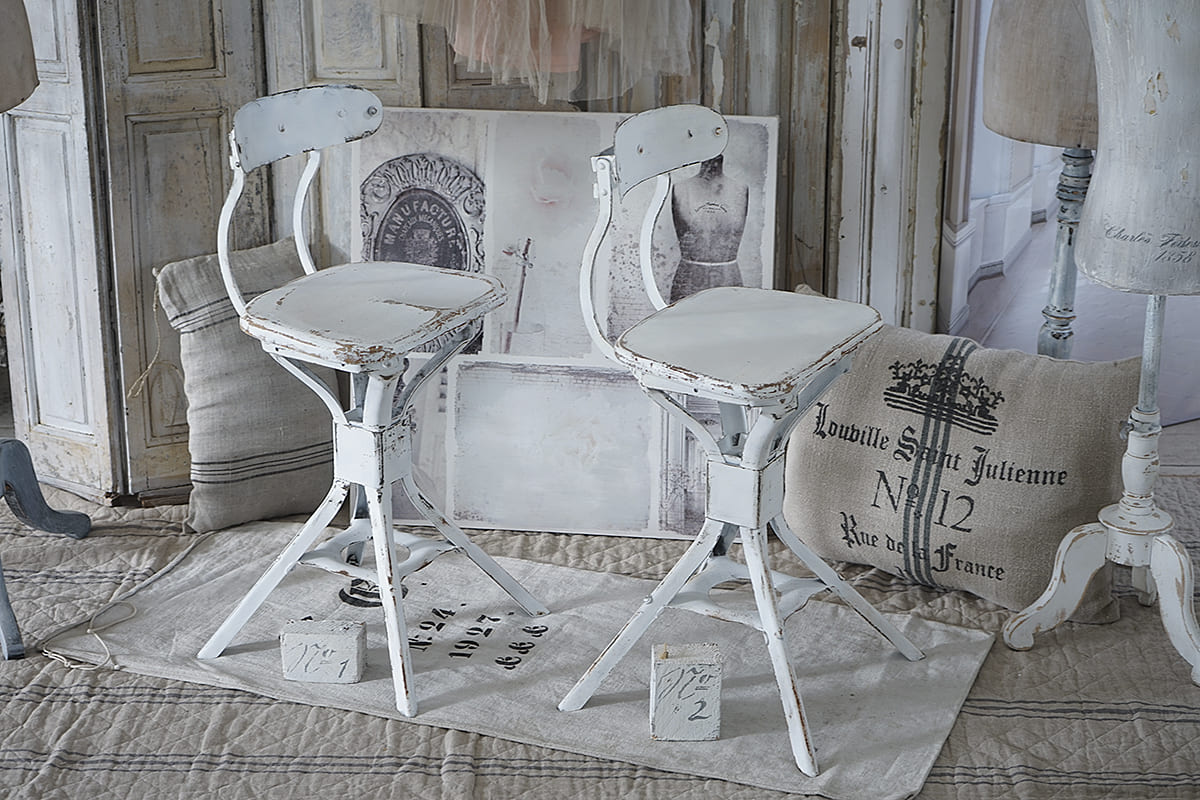 Zwei nostalgische Barhocker im Shabby Chic Stil, weiß lackiert mit abblätternder Farbe.