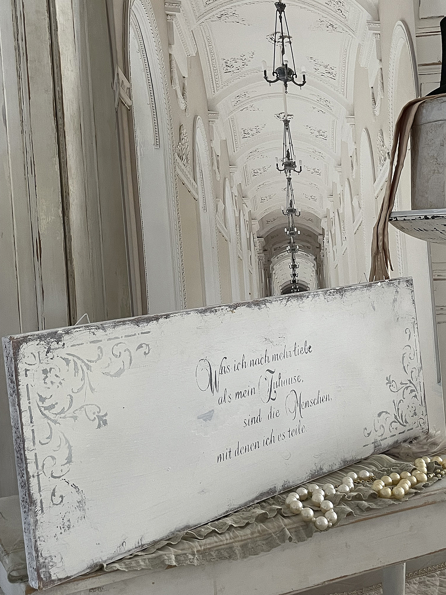 Wanddekoration mit emotiver Botschaft über Heimat und Beziehungen Wandbild mit dem Text: 'Was ich nach mehr liebe als mein Zuhause, sind die Menschen, mit denen ich es teile.'