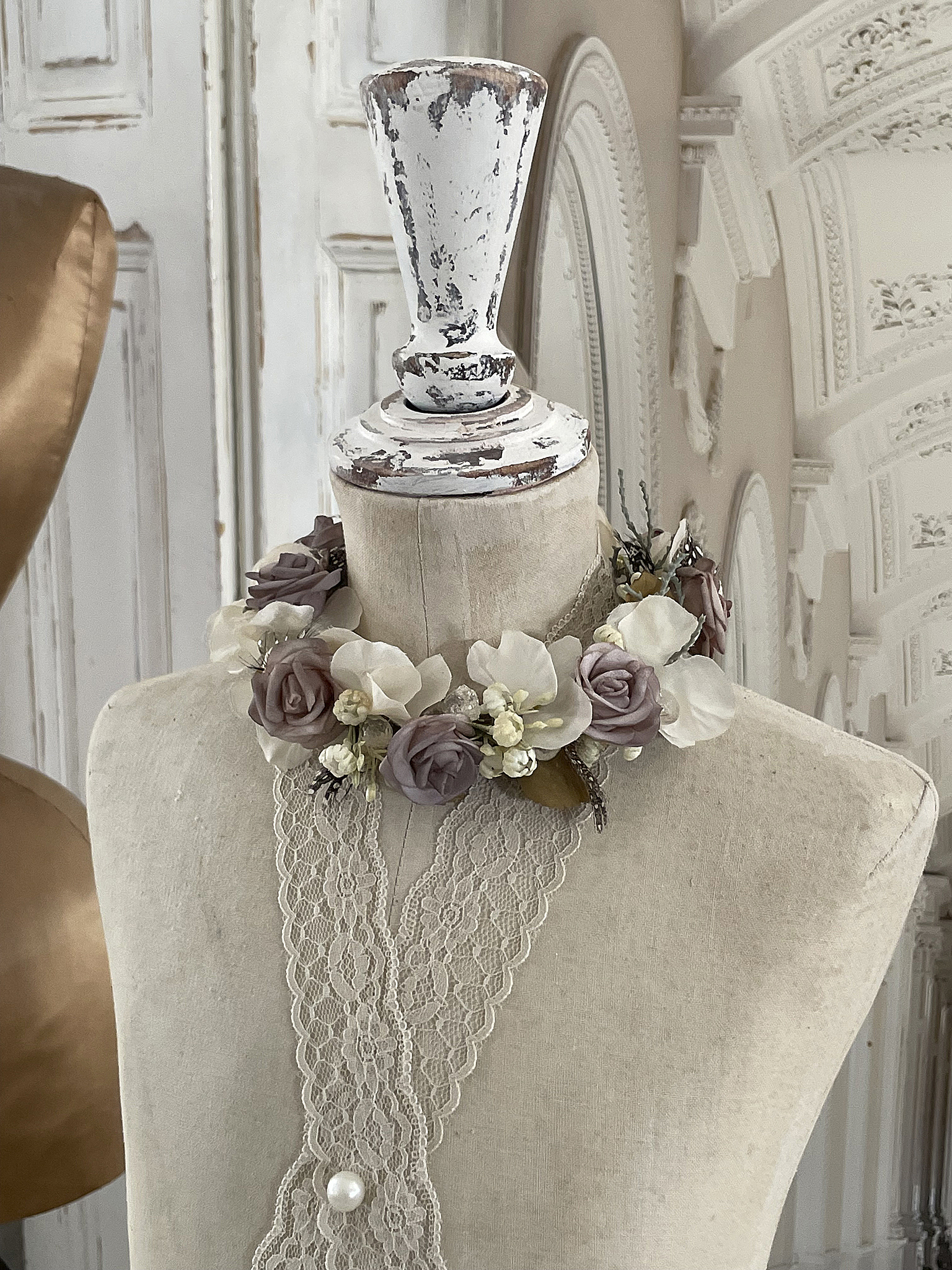 Kleidungsstück mit floraler Dekoration auf einer Schneiderpuppe Schneiderpuppe mit einer schönen Blütenkrone aus Rosen und anderen Blumen