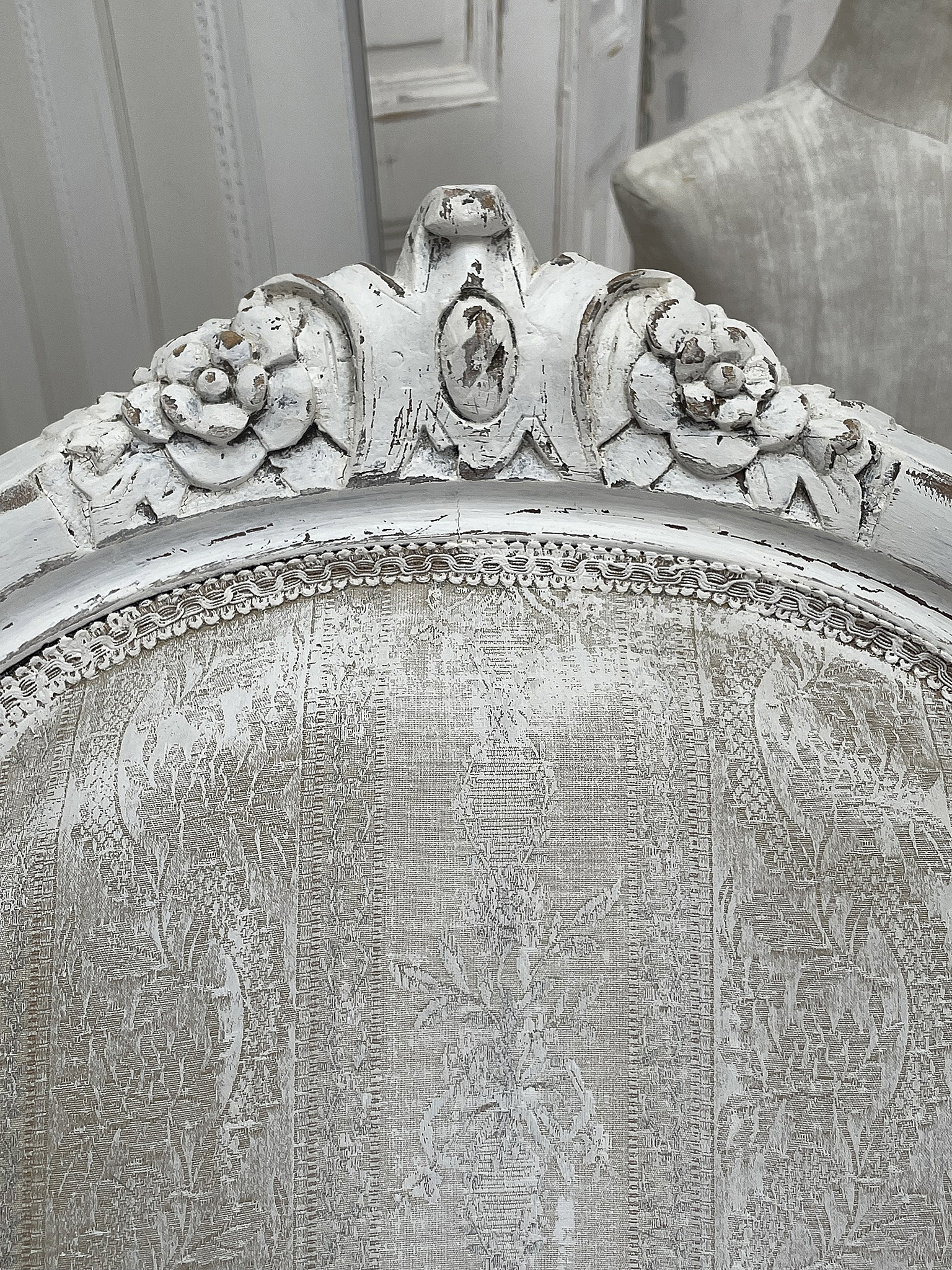 Eleganter Antik-Stuhl mit floralen Verzierungen Detailansicht eines antiken Stuhls mit weißen Verzierungen und floralen Motiven