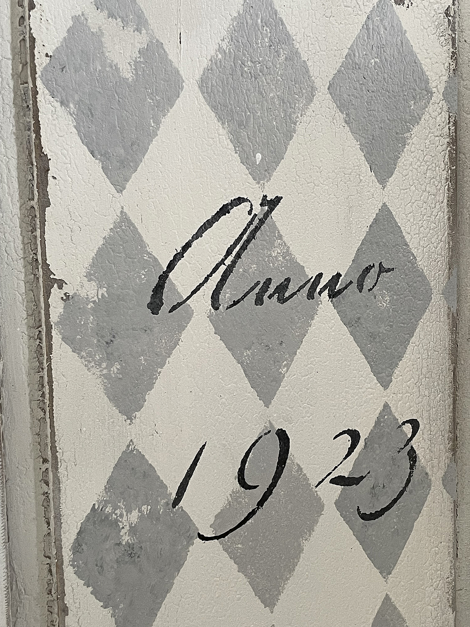Vintage Wandgestaltung mit Diamanten und Jahr 1923 Detailaufnahme einer Wand mit grauen Diamanten und der Jahreszahl 1923