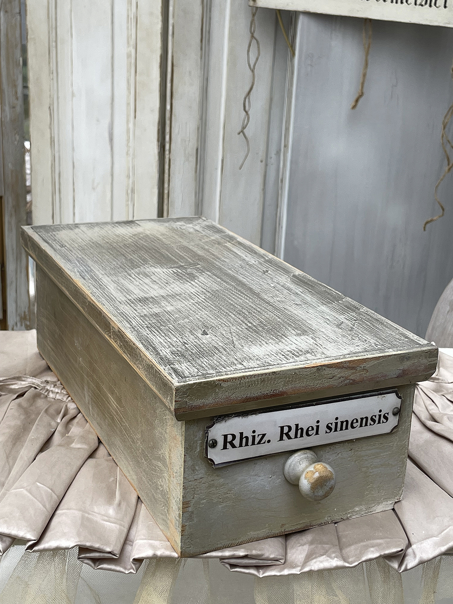 Holzkiste mit Beschriftung Rhiz. Rhei sinensis Antike Holzkiste mit der Bezeichnung Rhiz. Rhei sinensis auf einem eleganten Untergrund