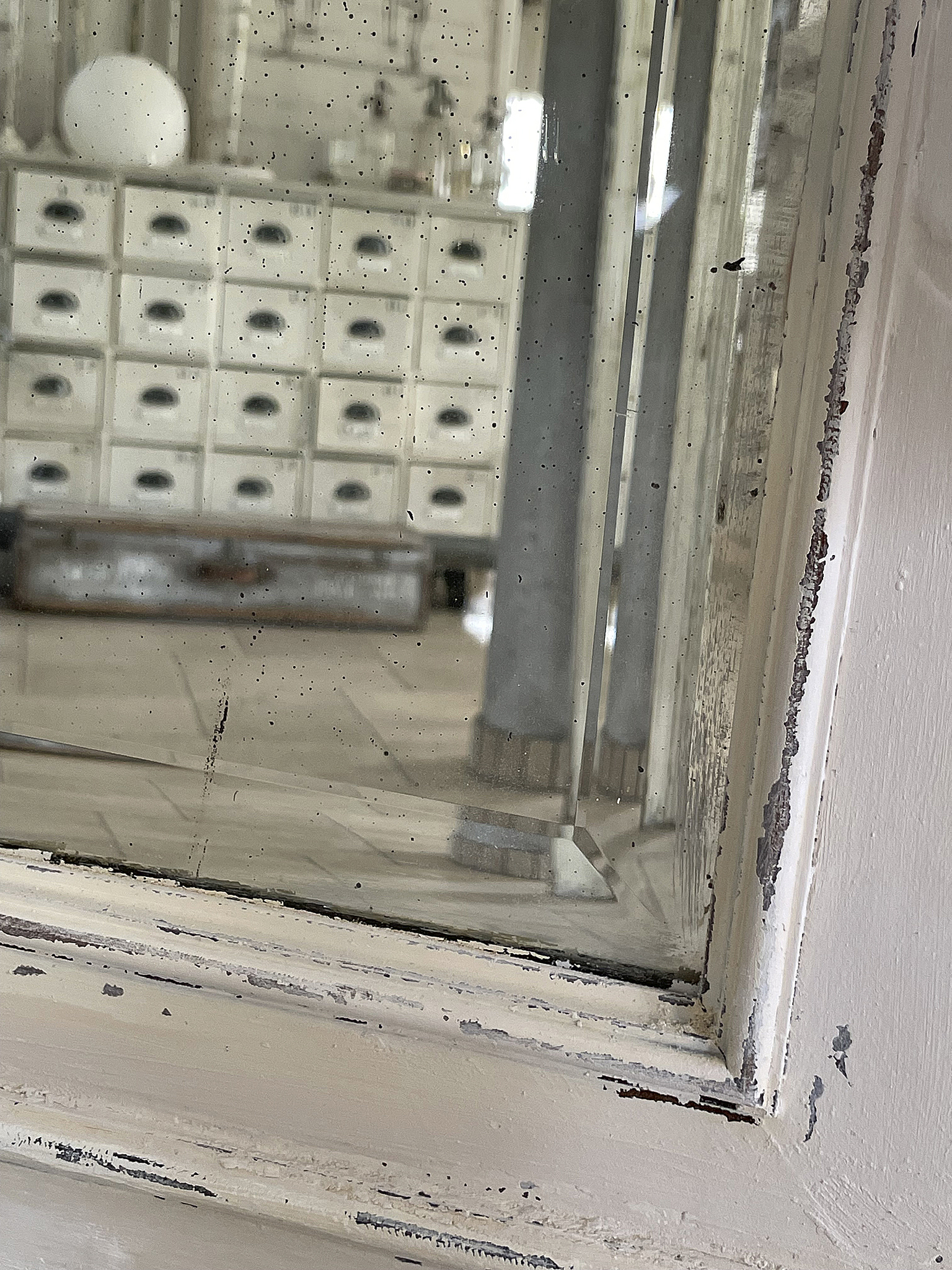 Schöner Einblick in einen stilvollen Innenraum mit einer Kommode und dekorativen Elementen Reflexion in einem alten Fenster mit Kommode und dekorativen Accessoires im Hintergrund