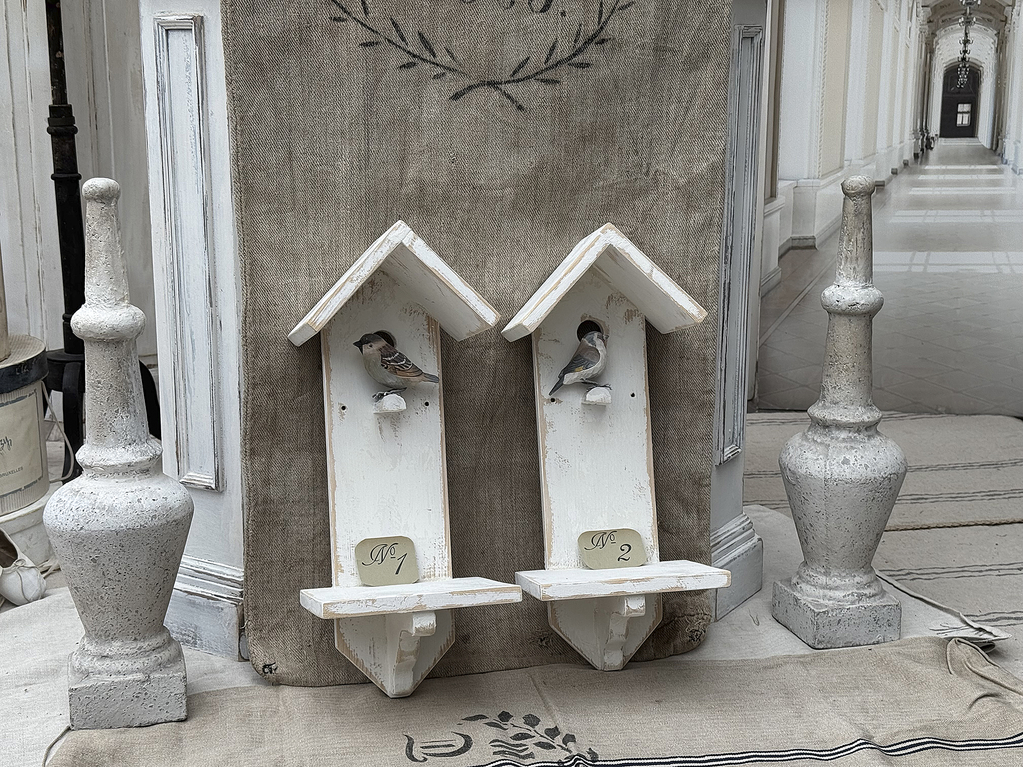 Dekorative Vogelhäuser im Vintage-Stil Schöne Vogelhäuser in Weiß mit kleinen Vögeln, umgeben von stilvollen Deko-Elementen