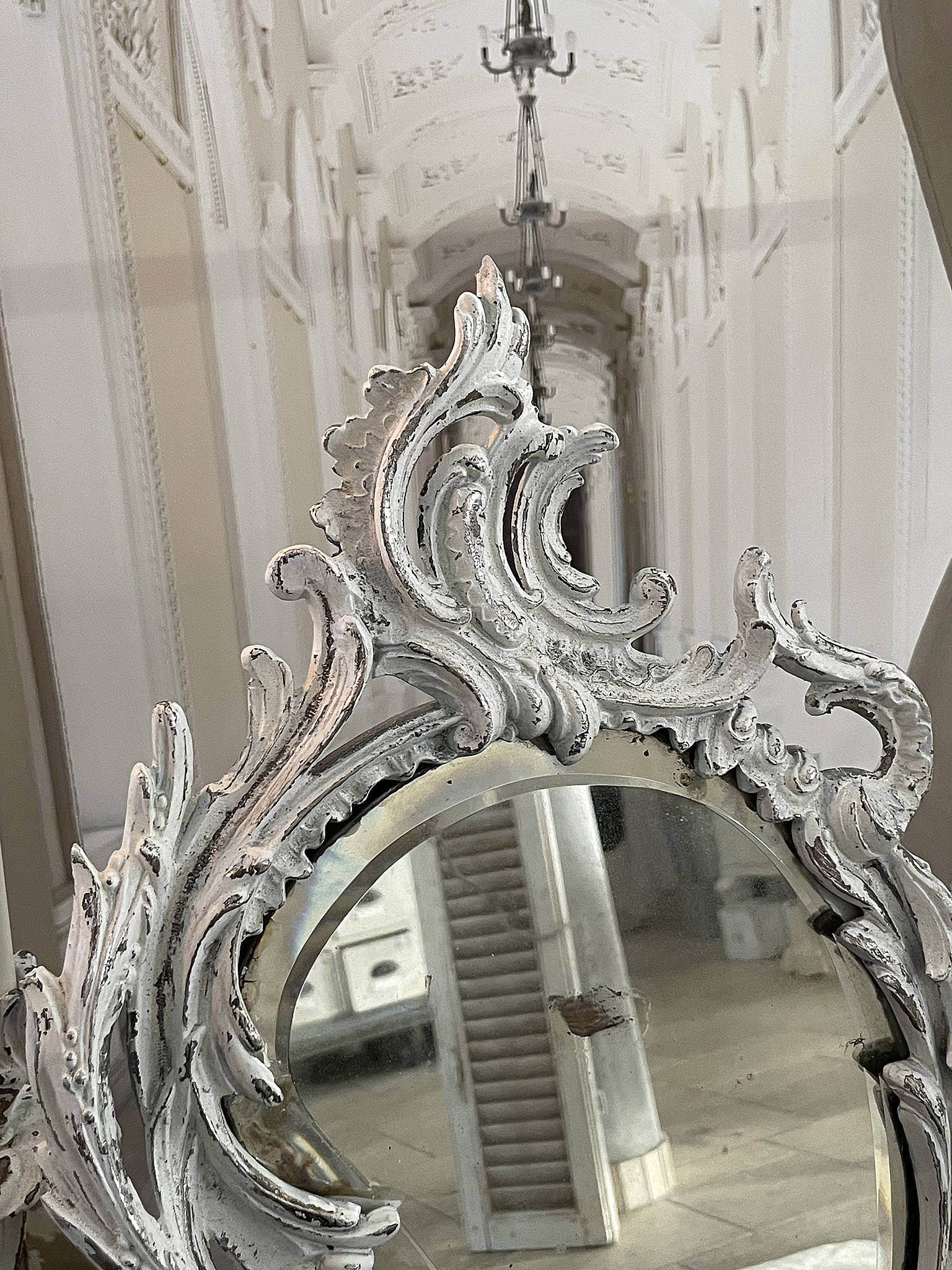 Eleganter Spiegel mit kunstvollem Rahmen in historischem Gebäude Detailaufnahme eines eleganten Spiegels mit verziertem Rahmen und Blick auf einen langen Flur