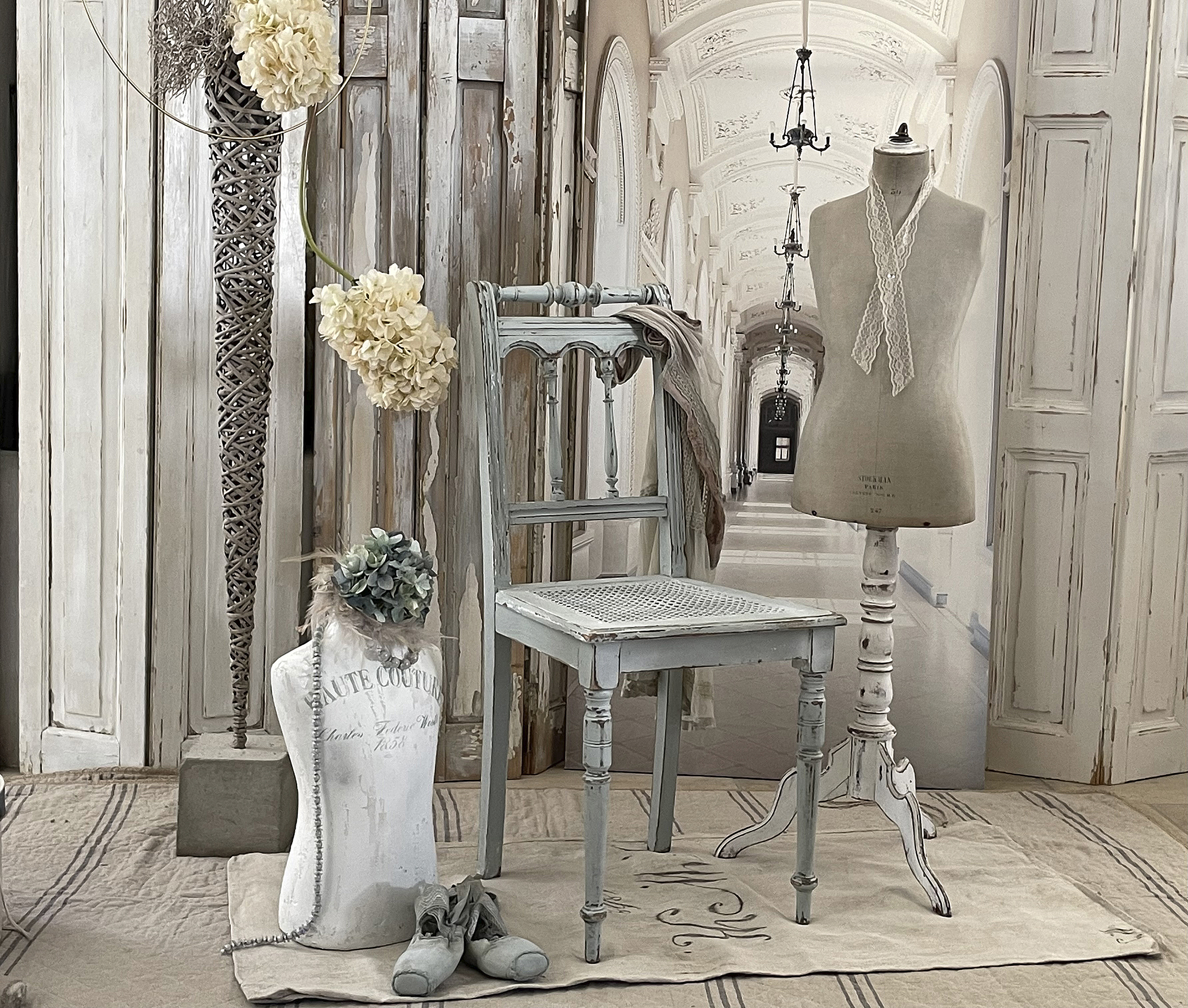 Elegante Dekoration mit vintage Stuhl und Mannequin in einem stilvollen Raum Stilvolle Inneneinrichtung mit einem vintage Stuhl, einem Mannequin und dekorativen Blumen