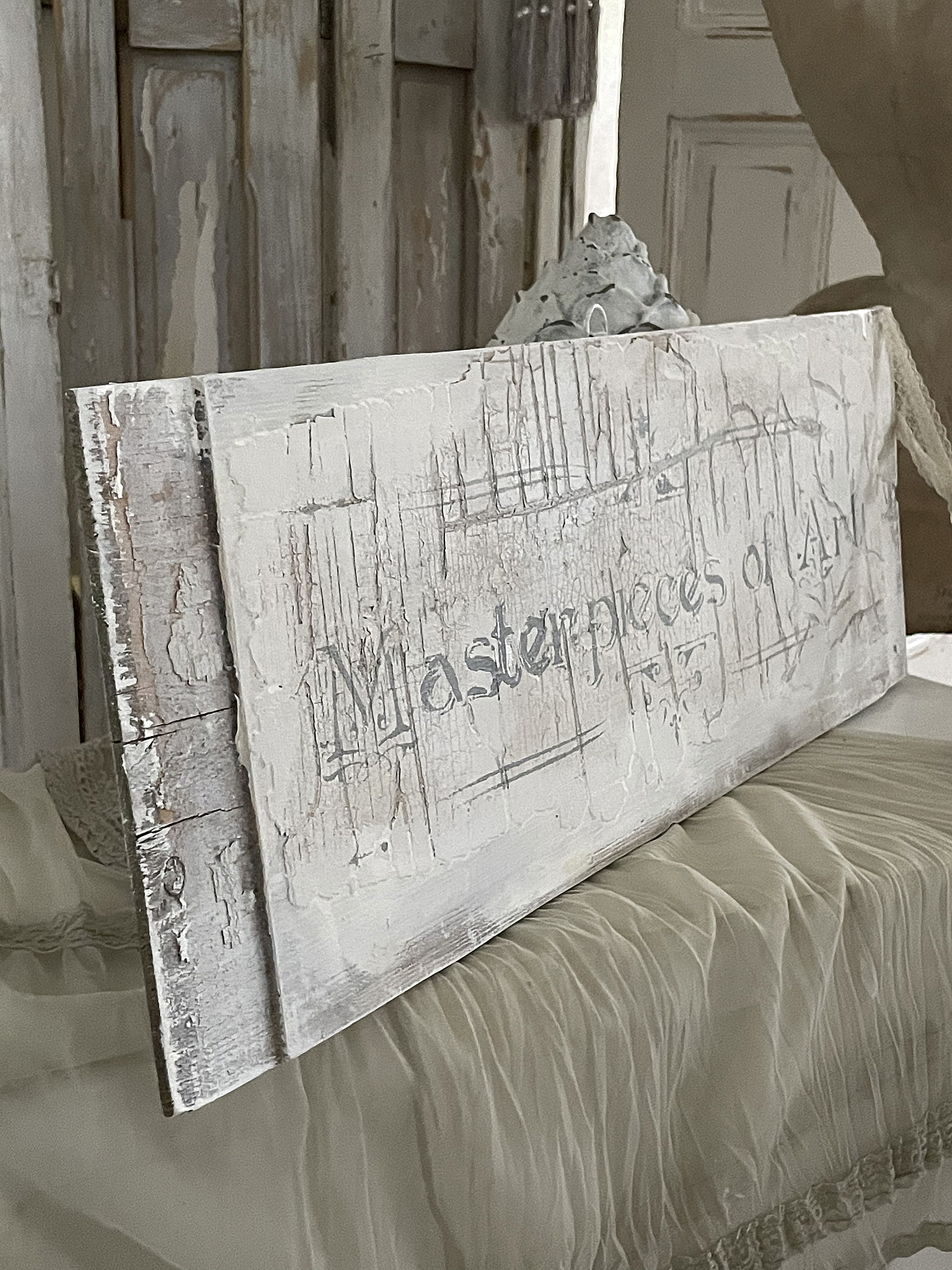 Ein rustikales Schild mit der Aufschrift 'Masterpieces of Art' aus verweathertem Holz, perfekt für die Wohnungseinrichtung.