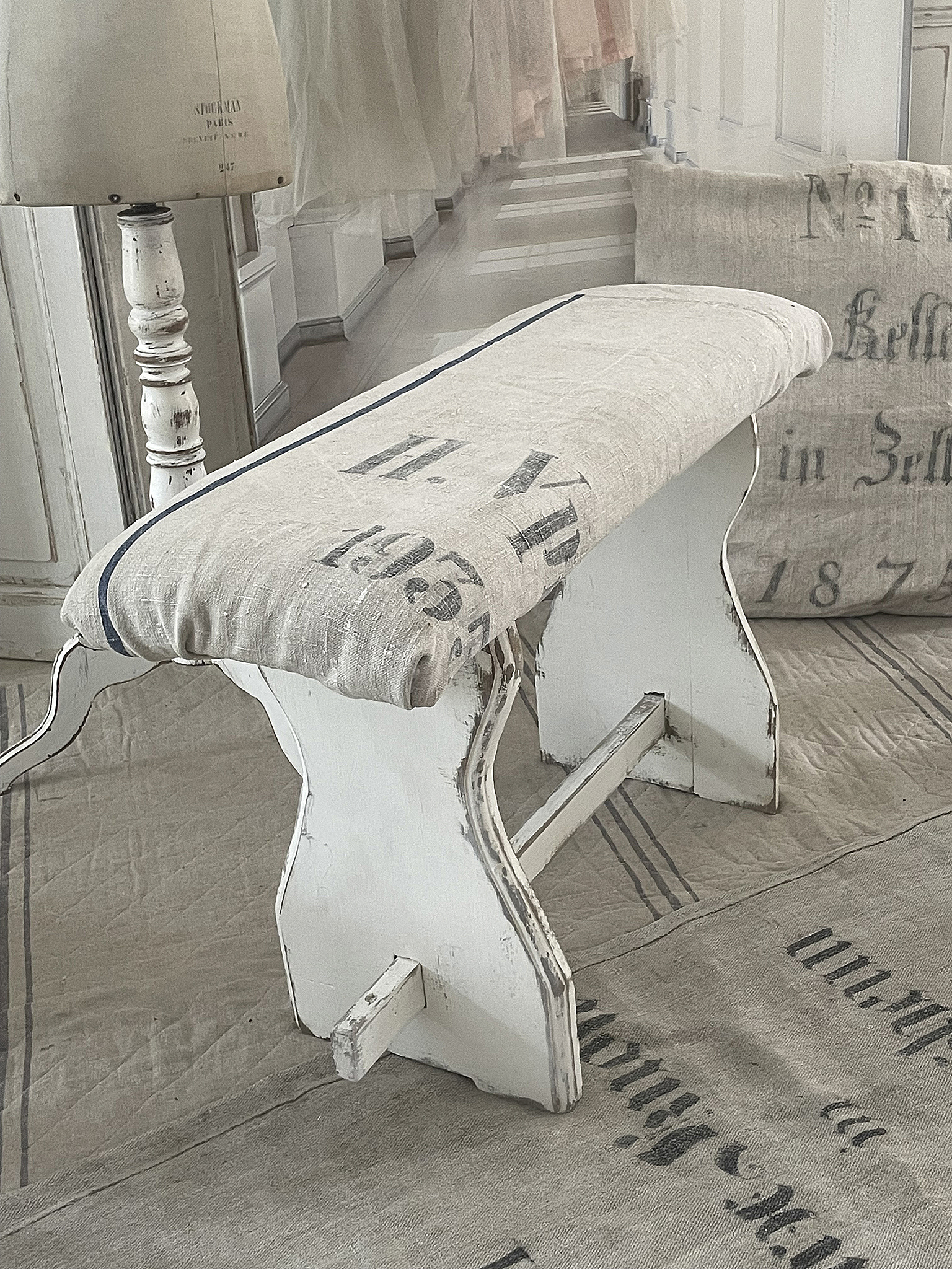 Skandinavischer Hocker mit gestreiftem Kissen im Vintage-Stil Eleganter weißer Hocker mit gepolsterter Sitzfläche und nostalgischem Design