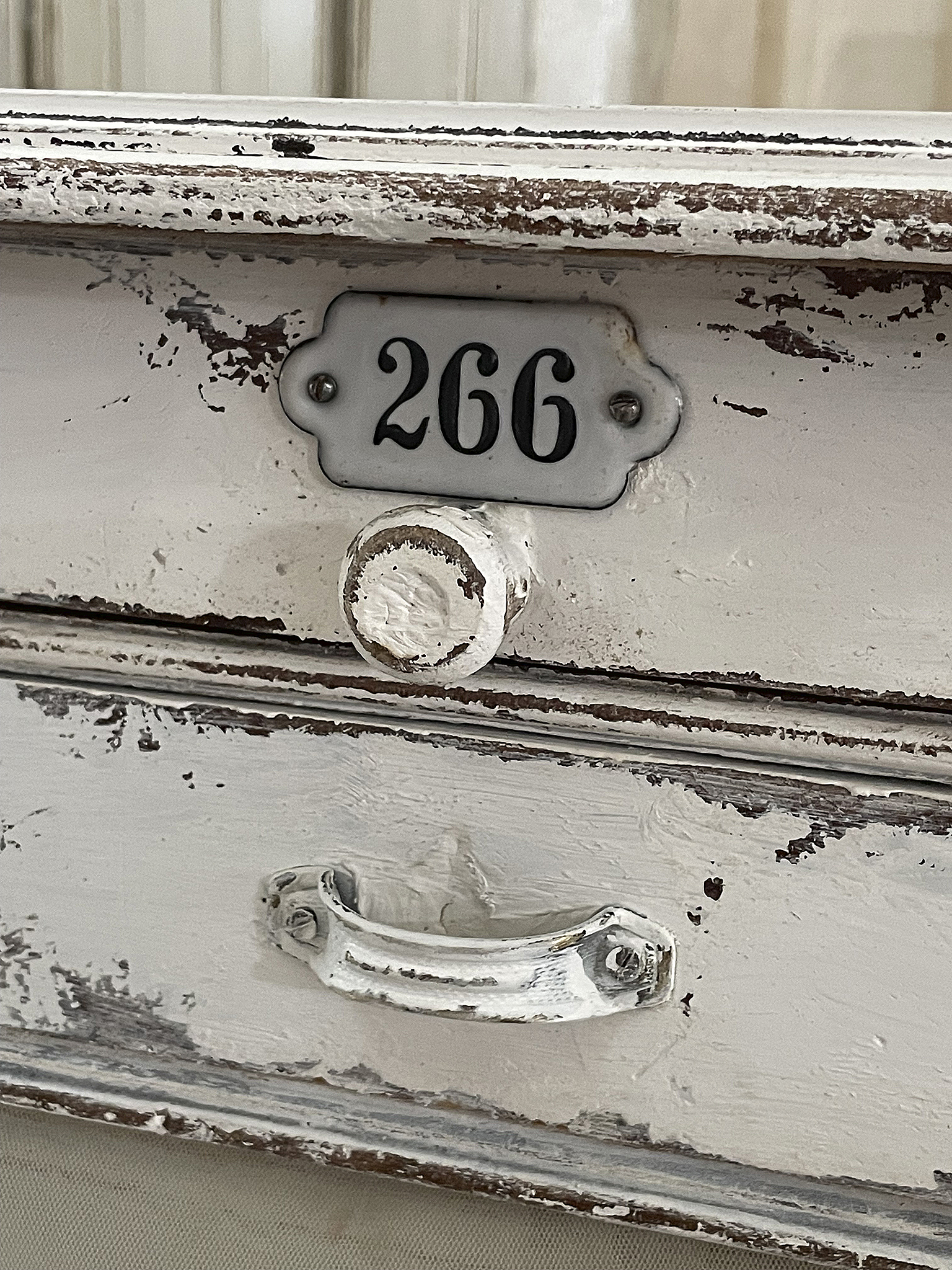 Vintage Schublade mit alter Nummerierung 266 und abgenutztem Design Detailansicht einer antiken Schublade mit der Nummer 266 und einem klassischen Griff