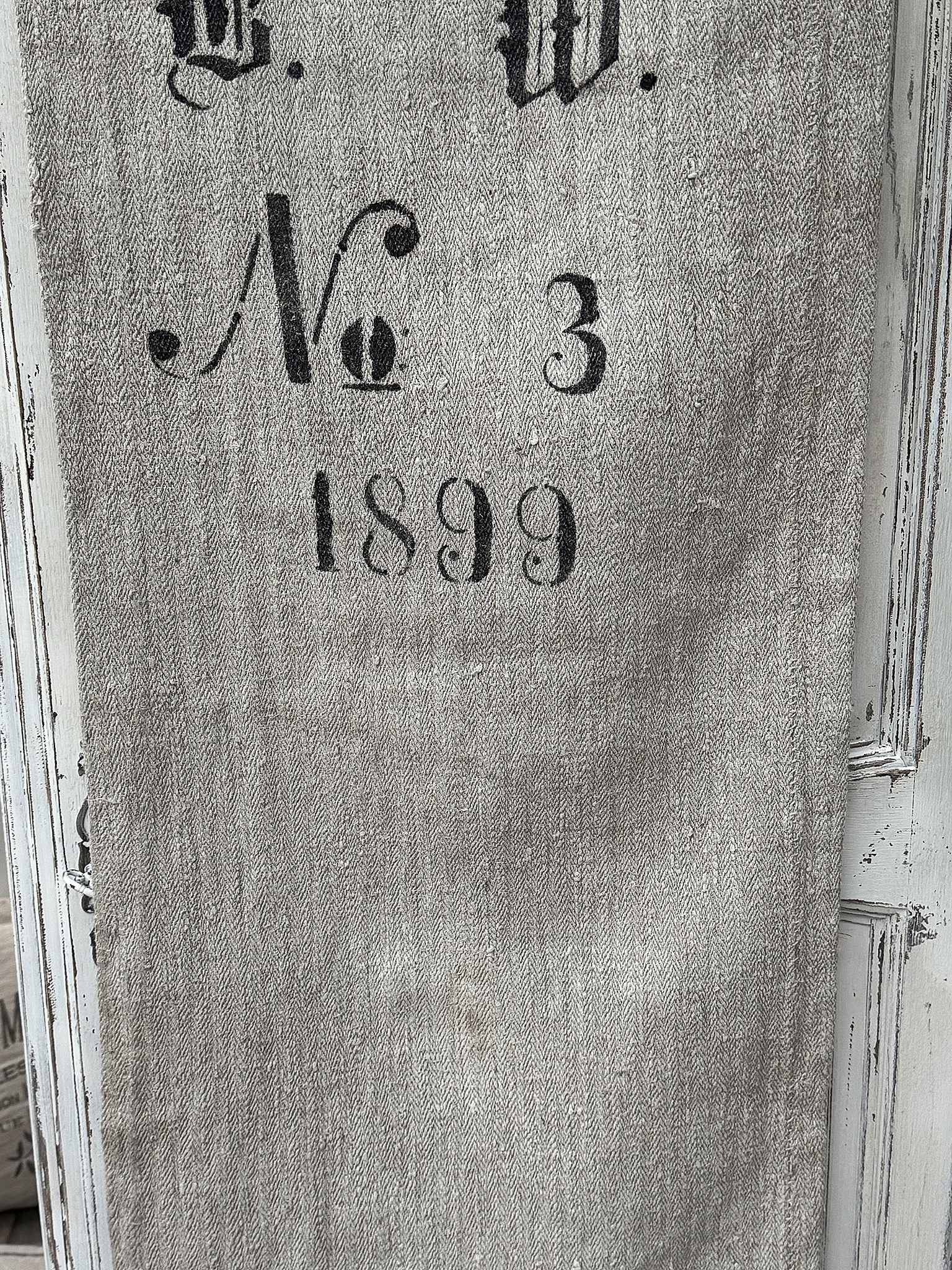 Detailaufnahme eines vintage Textils mit der Jahreszahl 1899 und der Nummer 3
