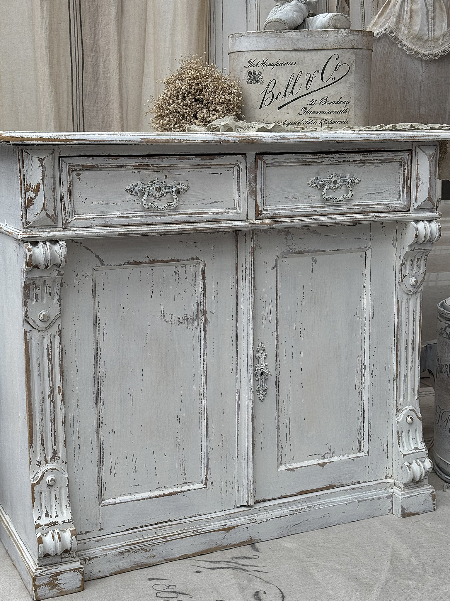 Antiker Sideboard mit Schubladen und detailreicher Verarbeitung Detailansicht eines antiken Sideboards in shabby-chic Design mit Schubladen und eleganten Verzierungen.