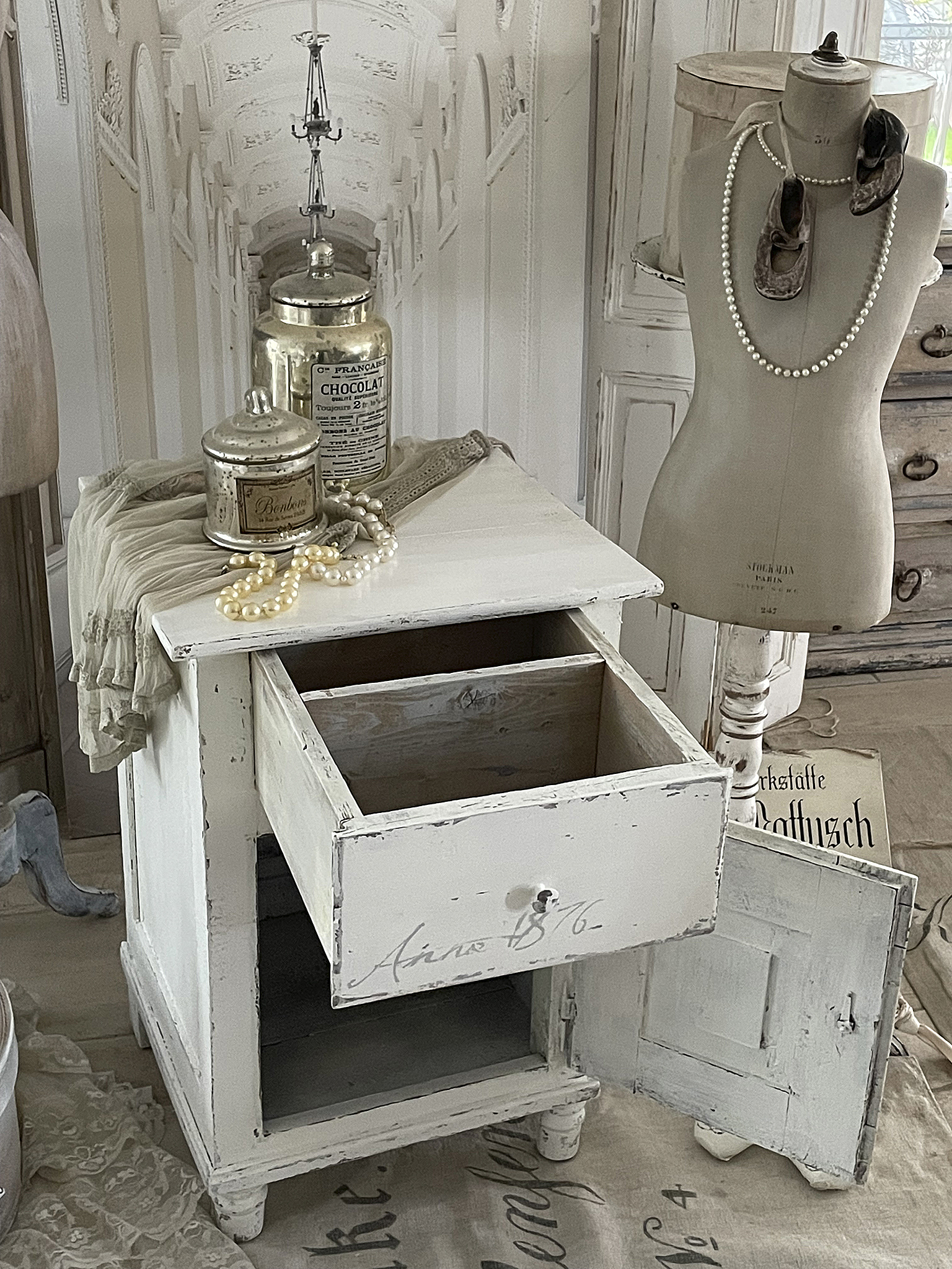 Antiker Beistelltisch im Shabby-Chic-Stil mit offenem Schubfach Beistelltisch aus antikem Holz im Shabby-Chic-Stil, ausgestattet mit Gläsern, Schmuckperlen und einer Schneiderpuppe