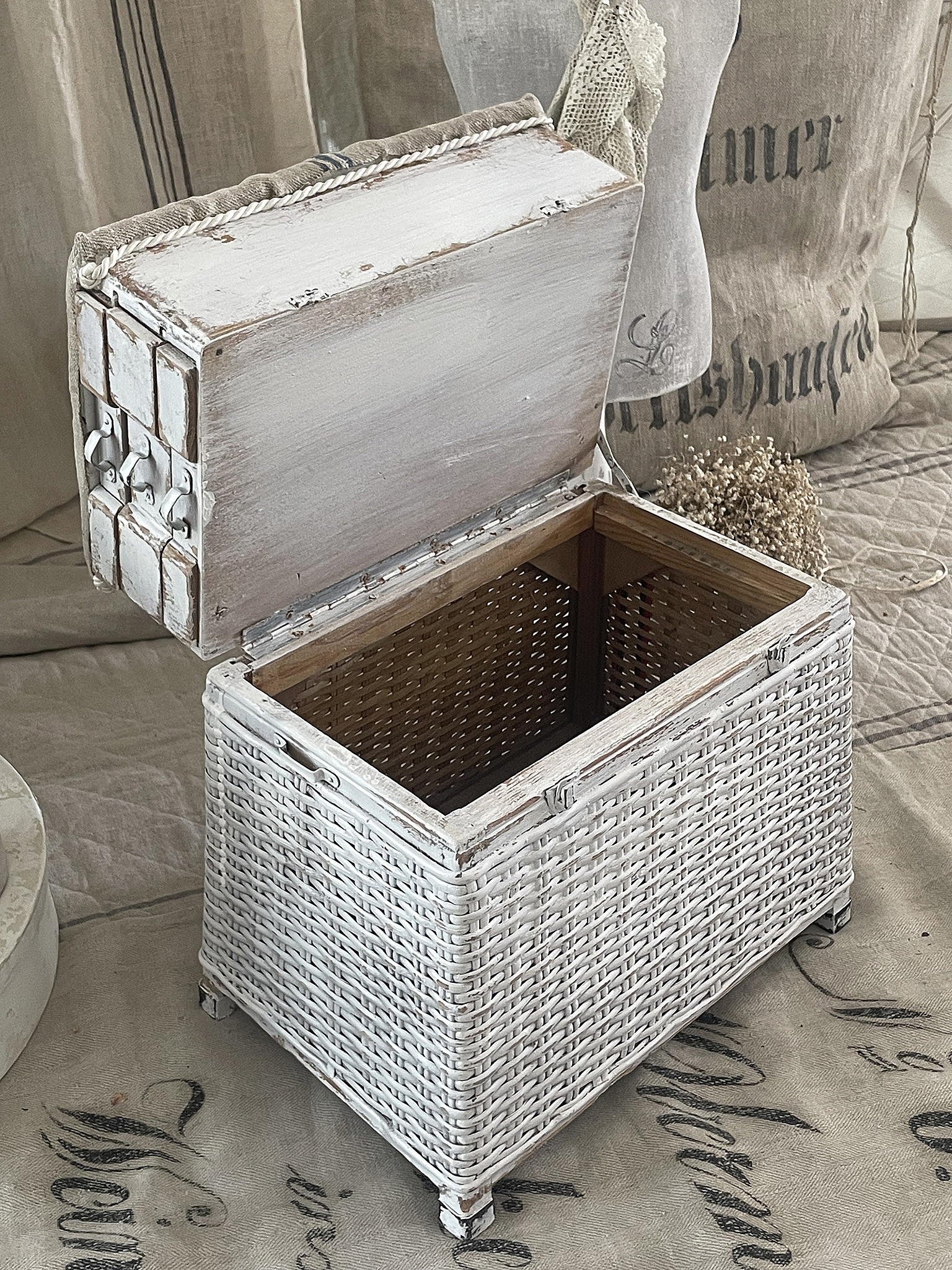 Kreative Aufbewahrungskiste aus geflochtenem Material in Weiß Schlichte und elegante Aufbewahrungskiste aus Rattan mit Holzdeckel, ideal für stilvolle Wohnräume.