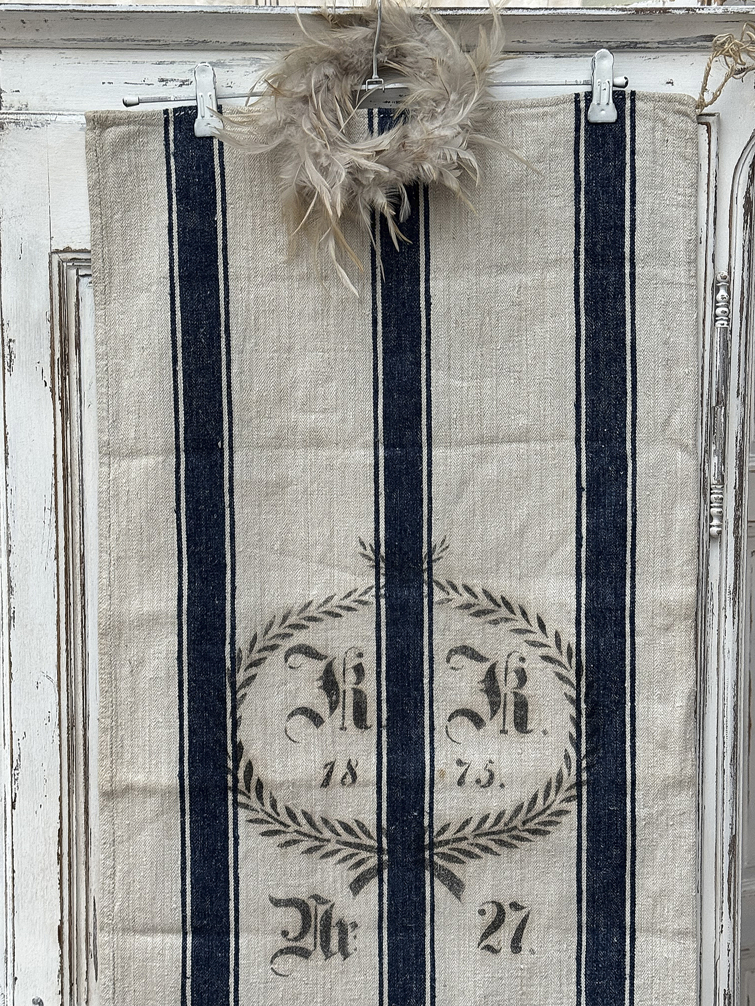 Ein nostalgisches Handtuch mit blauen Streifen und einem Wappen aus dem Jahr 1875, dekoriert mit einer Federkrone.