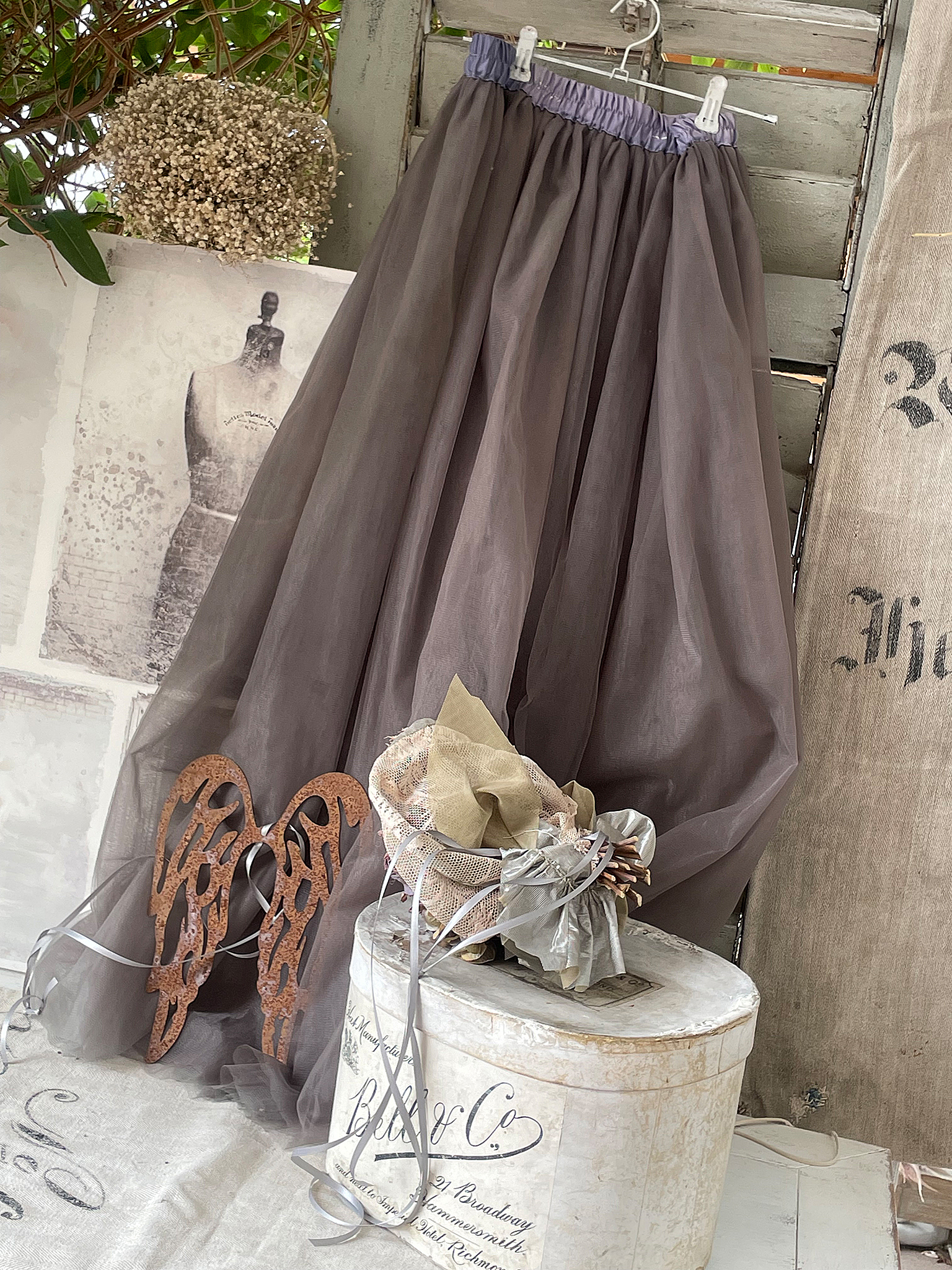 Eleganter, grauer Tüllrock mit bequemem Gummibund Schöner grauer Tüllrock hängt an einer Garderobe, umgeben von stilvollen Accessoires