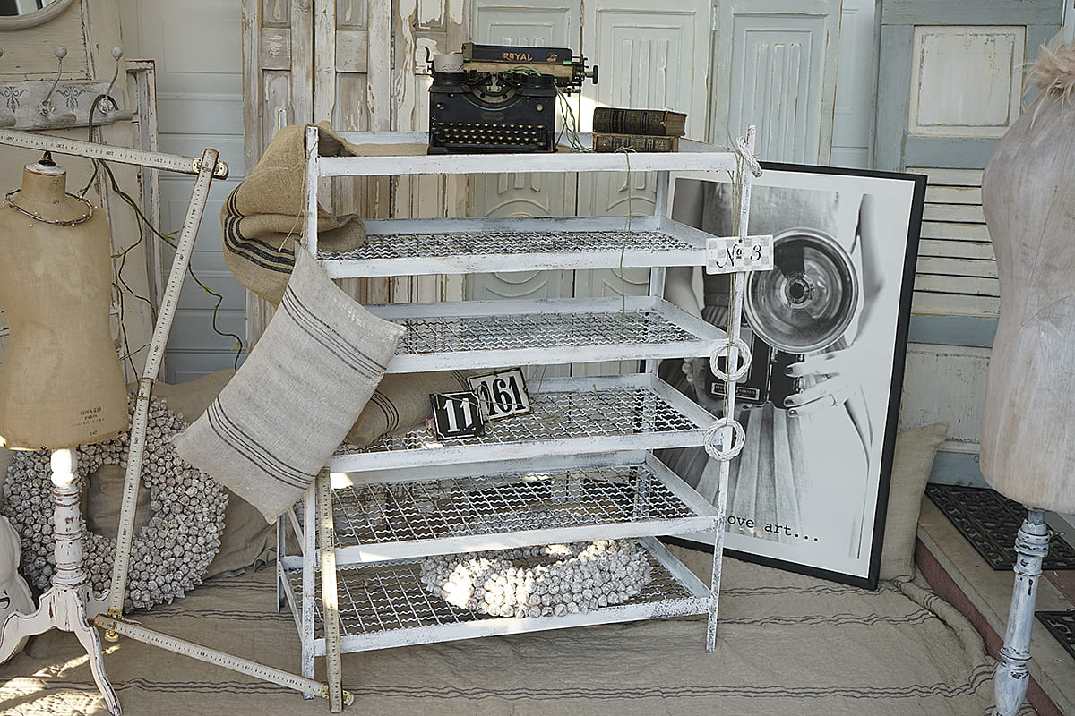 Ein elegantes, weißes Regal im Vintage-Stil mit einer Schreibmaschine und verschiedenen dekorativen Elementen.