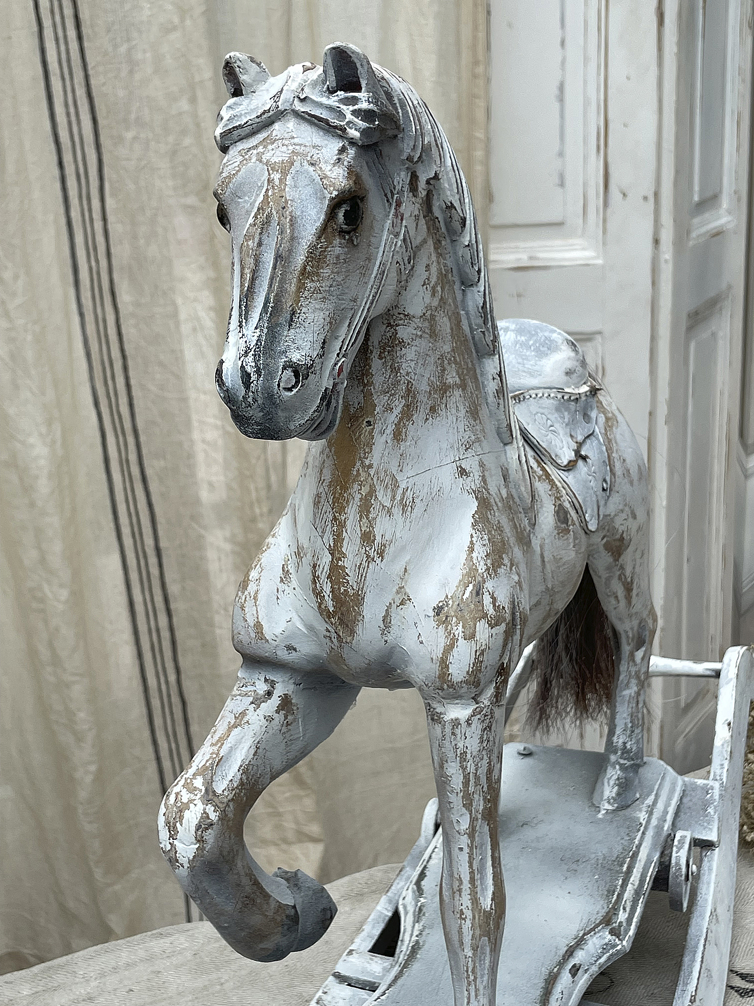 Vintage Holzspielzeug eines Pferdes, kunstvoll bemalt und detailliert gestaltet.