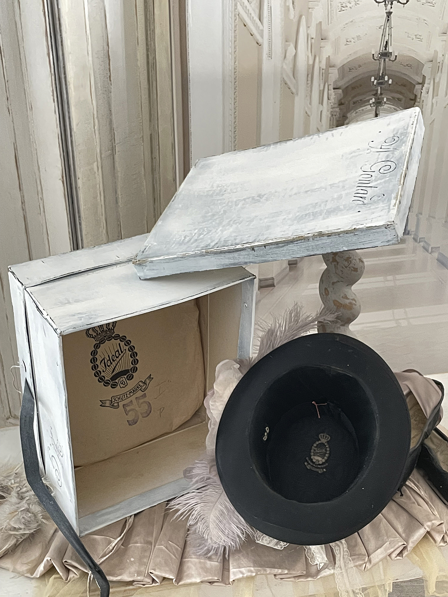 Vintage Hut in stilvoller Präsentation Schwarzer Vintage-Hut in Box mit Federn und eleganter Kleidung