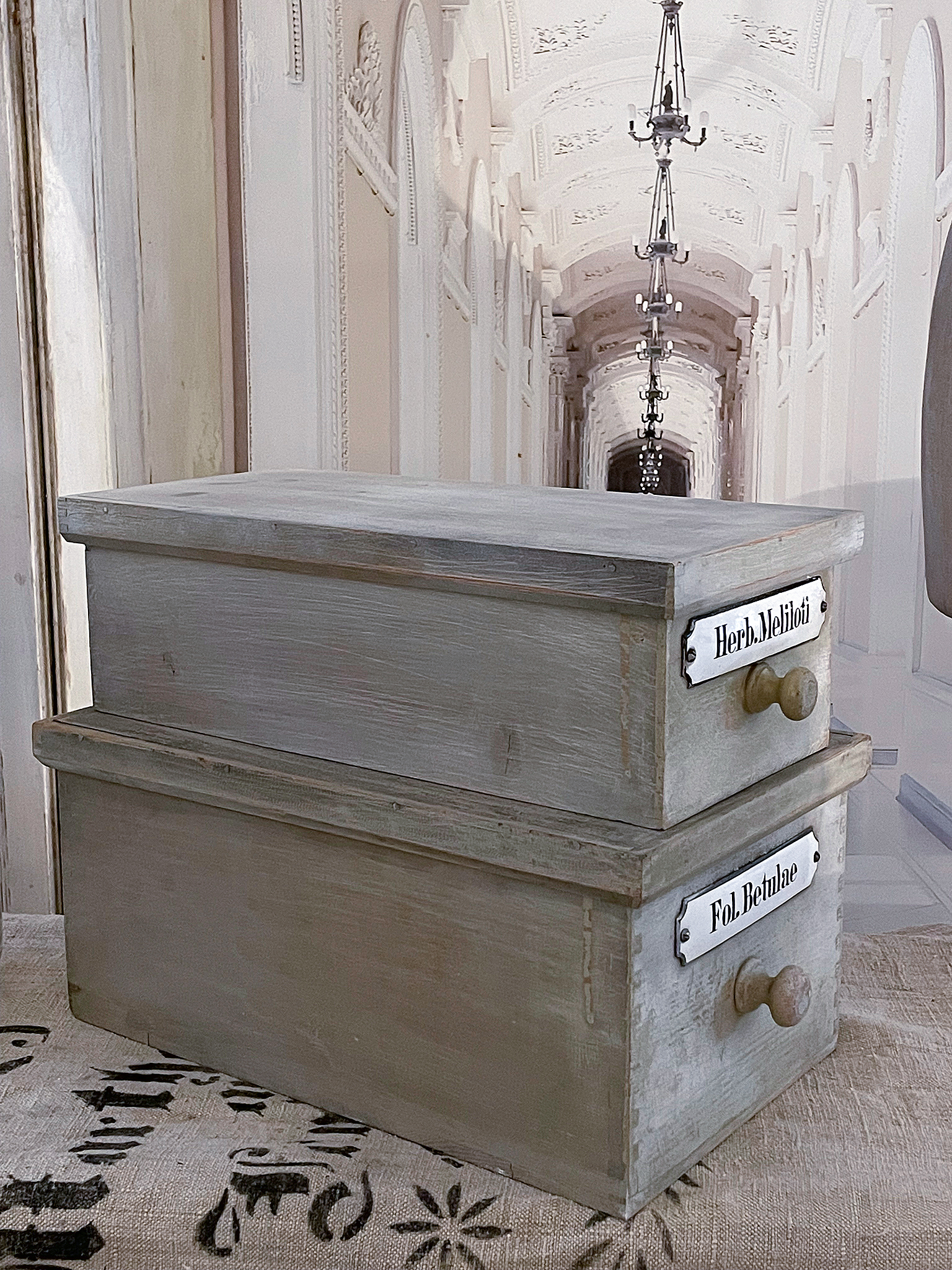 Zwei Holzboxen in rustikalem Stil auf einem Tisch mit dekorativem Untergrund