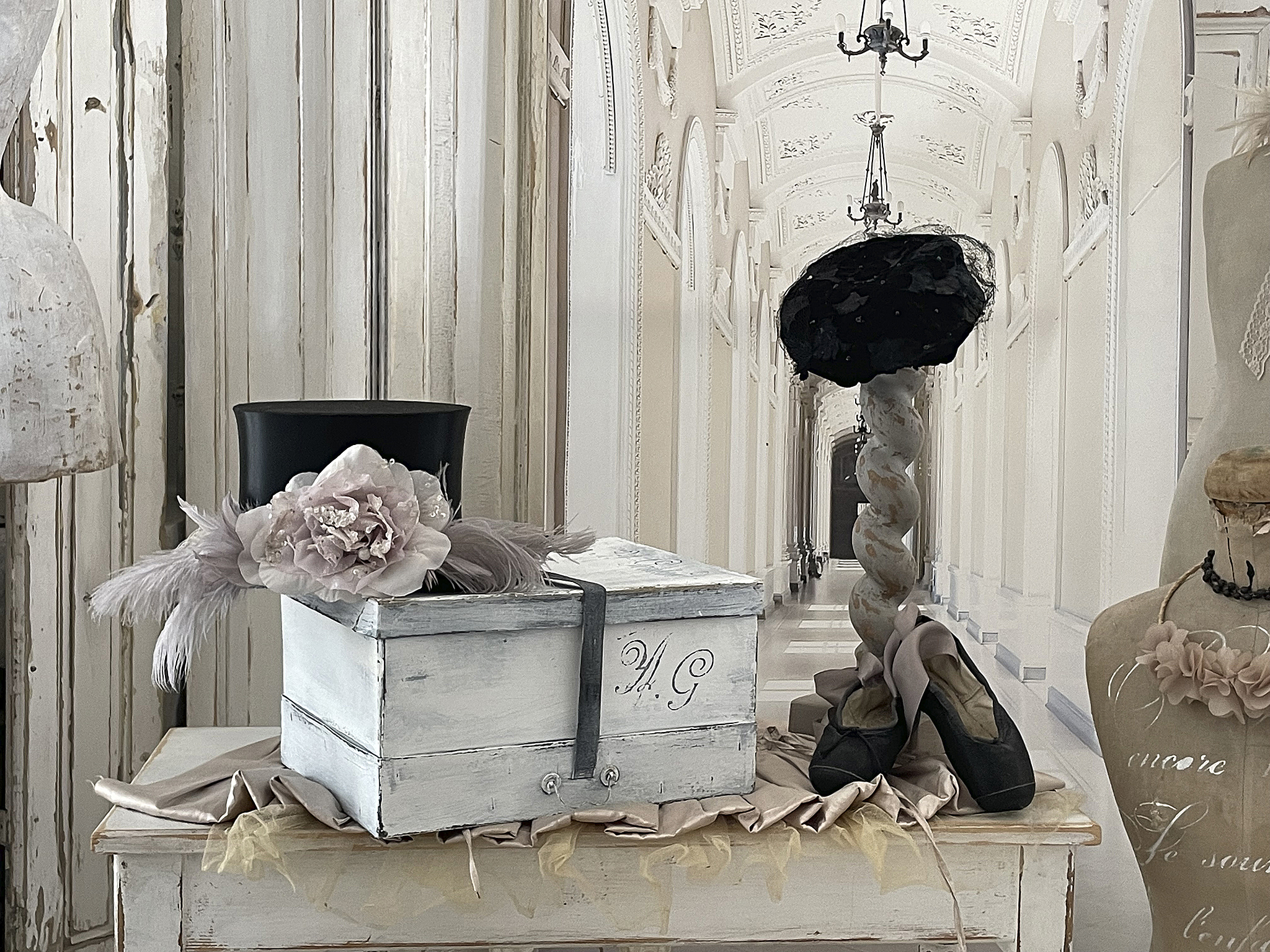 Elegante Dekoration mit Hut, Box und Schuhen in historischem Ambiente Hübsche Dekoration mit einer schwarzen Hutbox, einem gemusterten Hut, einer hübschen Blume und hochwertigen Schuhen in einem stilvollen, historischen Raum