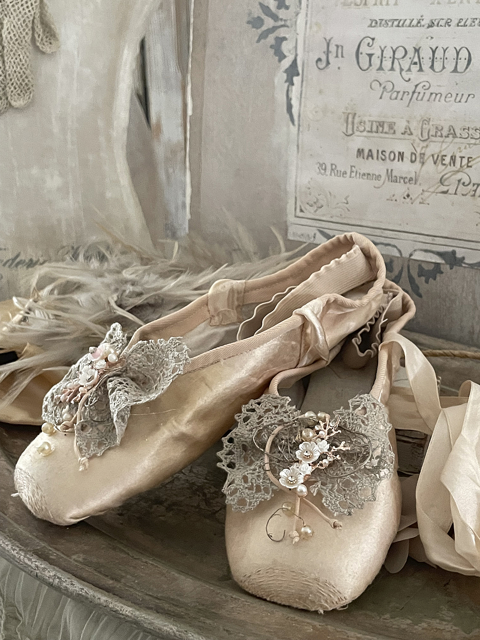 Elegante Ballettschuhe mit floralem Design in sanften Farben Zwei elegante Ballettschuhe mit dekorativen Blumen und Spitze auf einem rustikalen Tisch